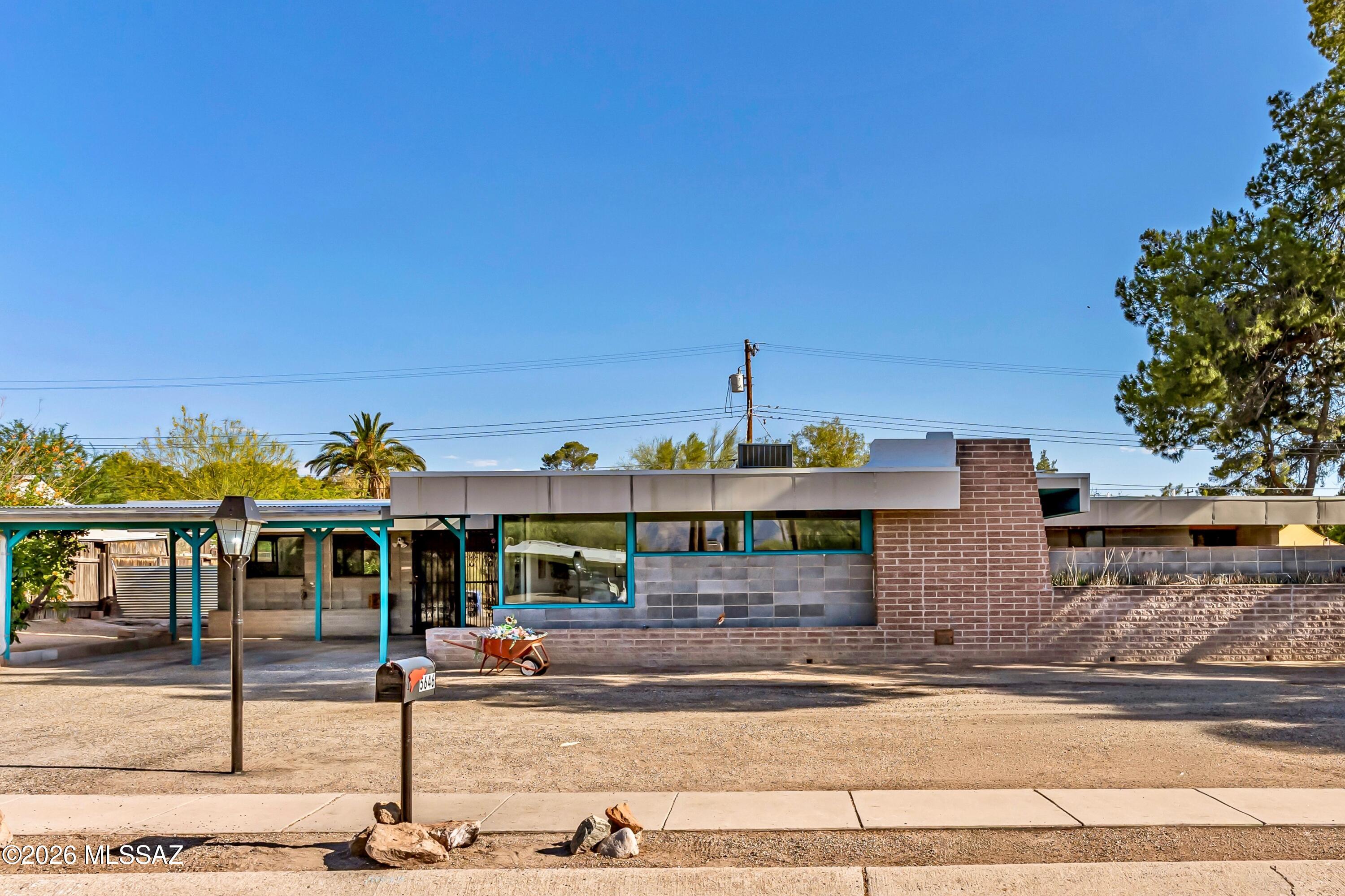Incredible opportunity to call this unique mid-century cement block home in Carlos Terrace yours! Offering timeless character, generous living space, dual-pane windows, a new main water line in 2025, HVAC replaced in 2025 & Evap Cooler replaced in 2024. Spanning a generous 2,332sqft, this 1950s Prairie-Style, 3bed, 2bath home features both a spacious living room and a separate family room flooded with natural light and stunning mountain views. Step outside to one of two completely enclosed oversized yards, creating the perfect setting for outdoor dining, relaxing, gardening, or hosting! Placed on a quiet cul-de-sac, this home is convenient to local restaurants, TMC Hospital, the Rillito River Bike Path, Fort Lowell Park, the University of Arizona and Davis Monthan AFB.