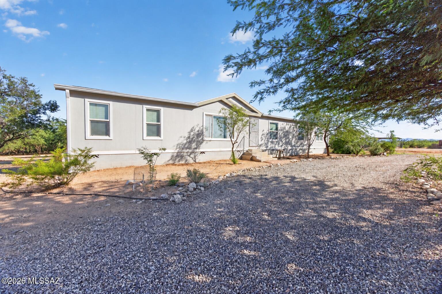 Bring your horses and enjoy country living on 4.2 acres with room to spread out! This spacious 4-bedroom + den home features a new roof, new A/C, new plumbing, new water heater, new carpet, fireplace, and new refrigerator and stove. The fully fenced property is ready for equestrian living with a pasture area, permanent round pen, 100' x 200' arena, tack room, hay storage and ample horse facilities. Mature trees surround the home, creating shade and privacy, while the shared well adds to the property's rural appeal. Plenty of space for horses, toys and Arizona living!