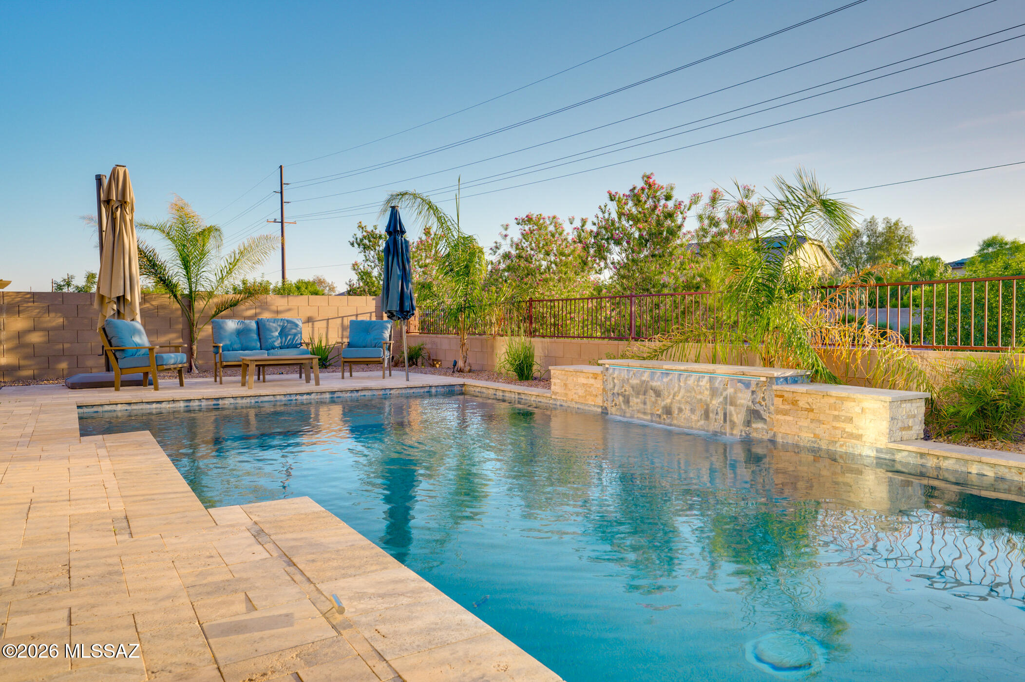 Range Priced. Seller will accept or counter offers between $524,888 and $549,888. Some homes check a few boxes. This one checks them all. Perfectly positioned on a premium lot backing to a wash and trail system with no rear neighbors, this exceptional Gladden Farms property combines privacy, luxury, and versatility with breathtaking mountain views, colorful Arizona sunrises, and unforgettable sunsets right from your backyard. Inside, you'll find a thoughtfully designed 3-bedroom, 2-bath split floor plan with soaring 10-foot ceilings throughout, creating an open, spacious feel from the moment you walk in. The gourmet kitchen serves as the heart of the home, featuring double ovens, a stylish neutral backsplash, abundant cabinetry, granite countertops, designed for gathering, entertaining, and everyday living. The private primary suite is a true retreat, complete with dual granite vanities and a custom built-in electric fireplace accented by beautiful stonework, adding warmth and character rarely found in a primary bedroom. Step outside and discover your own resort-inspired oasis. The backyard showcases low-maintenance turf, elegant travertine decking, and a stunning PebbleTec self-cleaning pool complete with a waterfall feature and color-changing LED lighting. With a view fence framing the natural desert backdrop, you'll enjoy peaceful mornings, spectacular sunsets, and endless Arizona evenings under the stars. And then there's the showstopper--an incredibly rare RV garage. Whether you're storing an RV, creating the ultimate workshop, housing up to four vehicles, setting up a home gym, storing recreational toys, or building the hobby space you've always wanted, this flexible space offers possibilities that are nearly impossible to find in today's market. Located just moments from Paws N' Claws Park, multiple neighborhood parks, miles of trails, The Loop, Fry's Marketplace, dining, and Marana's continued growth and development, this home delivers both lifestyle and location. Homes offering mountain views, no rear neighbors, a resort-style pool, and a versatile RV garage are few and far between. Don't wait--schedule your private showing today and discover why 12537 N Denton Way may be the one you've been waiting for.