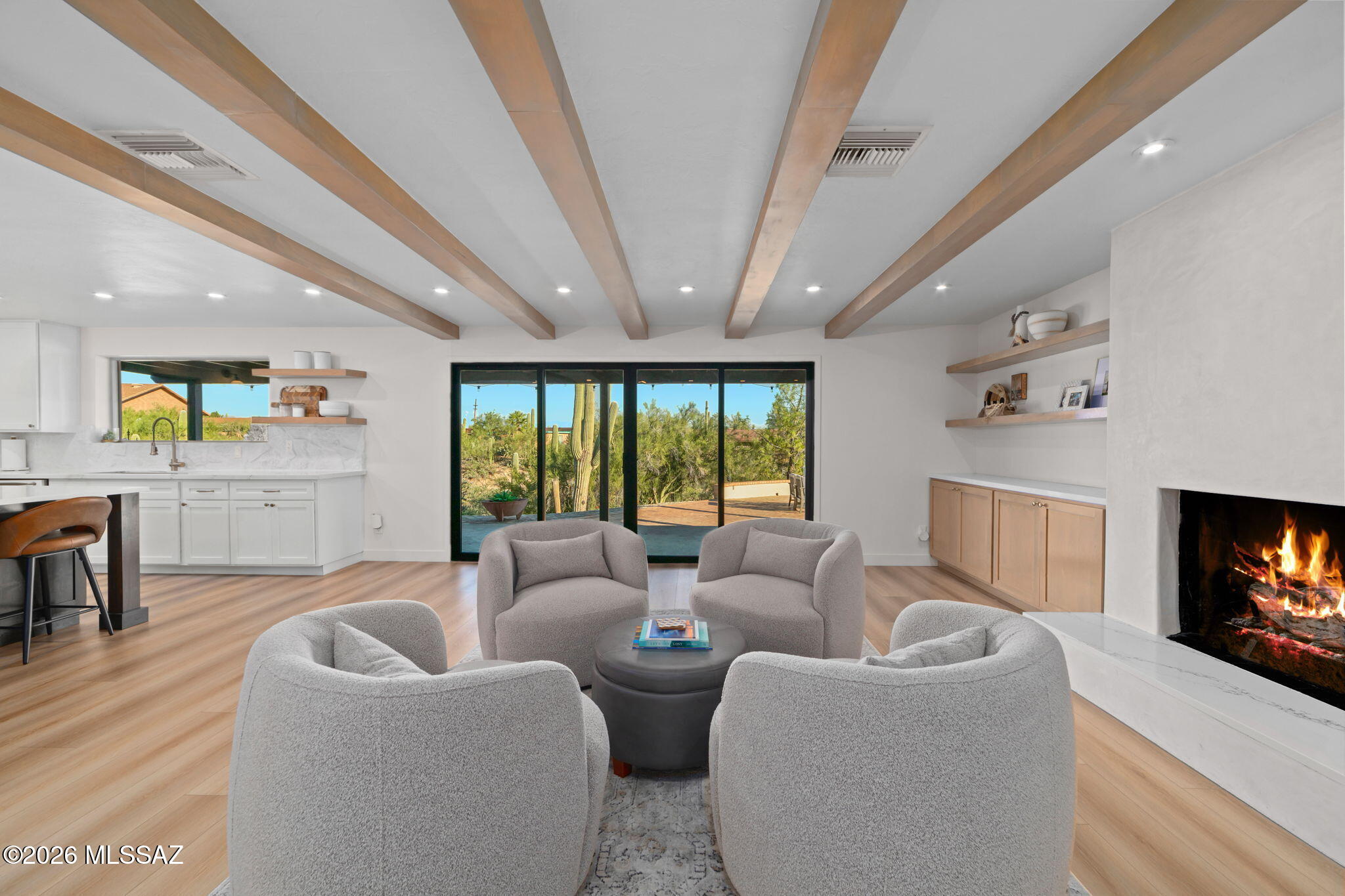 Imagine starting your morning with views of the Catalina Foothills, enjoying a quiet cup of coffee on your extensive covered patio while watching the sunrise & local wildlife peacefully cross the natural wash beyond your backyard. In the afternoons, step into your newly re-plastered, sparkling pool. At night, enjoy panoramic vistas of the city lights as you host unforgettable dinners with family & friends, perfectly blending privacy, natural beauty, & refined luxury.
Inside, discover rich architectural details, striking beamed ceilings, graceful archways, & abundant natural light. A warm family room with a cozy gas fireplace flows effortlessly into a chef-inspired kitchen featuring a spacious island & an open connection to the main living spaces.
Click More to Keep Reading... The primary suite offers a grand bathroom with a soaking tub & a newer tadelakt plaster walk-in shower featuring two showerheads for a luxurious, spa-like experience. The additional bedrooms provide ample space & comfort for family or guests.

Beyond the main living areas, a separate office space provides a quiet & productive environment ideal for remote work, a small gym, or an art studio.

This modern hacienda, with its breathtaking views of the surrounding mountains & twinkling city lights, is just moments away from Tucson's finest outdoor recreation, hiking trails, golf courses, upscale shopping, & dining options. With a convenient drive to the University of Arizona & downtown, this property captures the true essence of refined desert living!
