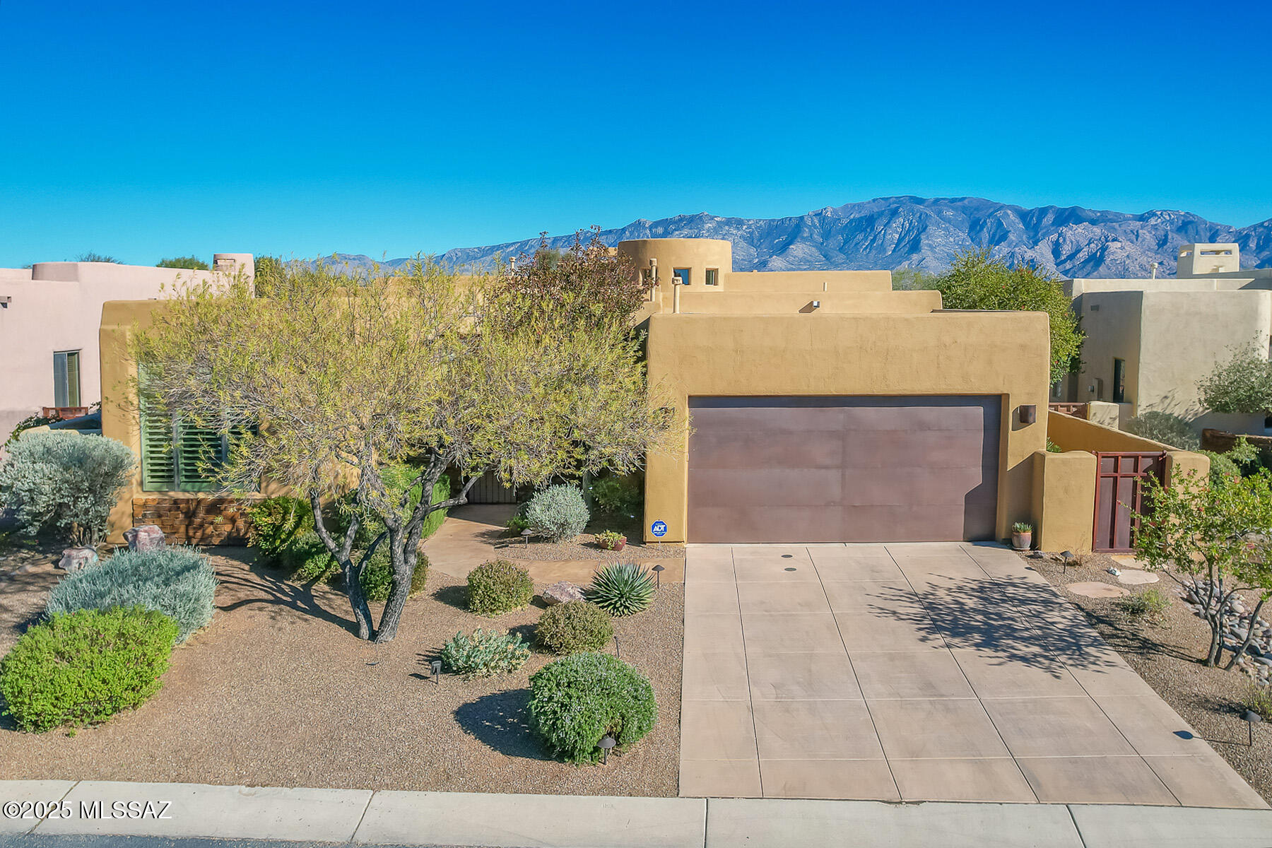 Nestled within a gated enclave of homes designed by renowned architect Kevin Howard, this exceptional residence is in the heart of Oro Valley. close to golf, hiking, biking, dining and more. The main home offers 3BD/3BA, complemented by a private 1BD/1BA casita, totaling 2,528 square feet of thoughtfully designed living space with 2 new HVACs. The spacious great room showcases striking custom wood beams and a charming gas fireplace, seamlessly flowing into the chef's kitchen. The kitchen features beautiful custom cabinetry, premium countertops, and top-of-the-line appliances, including a wine refrigerator perfect for entertaining. Alder doors and cabinetry throughout the home add warmth and timeless elegance, while travertine flooring enhances most living areas. The expansive primary suite