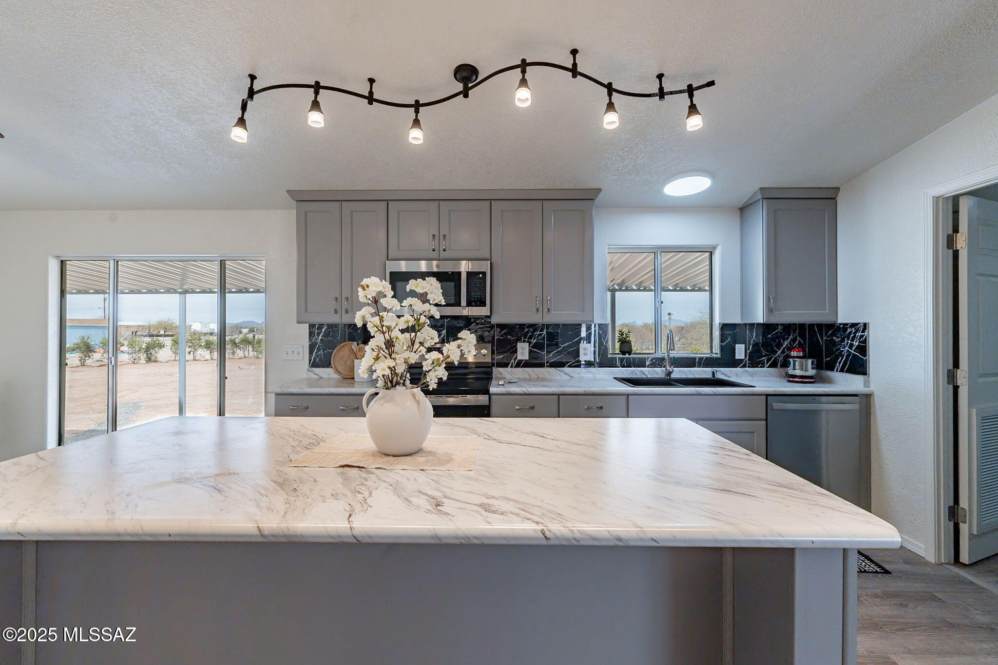 OPPORTUNITY FOR SELLER CARRY! This magnificent completely remodeled home can be a 3 Bdrm & Den/Office or a 4 Bdrm and 2 bath. Beautiful custom kitchen cabinets with soft close drawers, an oversized island which can seat 3 extra people, SS appliances, including Refrigerator and a stand up freezer in the laundry room. Beautiful new cabinets with soft close drawers and lots of counter space! Walk out onto your primary bedroom deck, home has 3000 SF under awning/carports. Owners didn't miss a thing when it comes to upgrades. A new A/C and heating unit with full warranty so no worries there! A custom built wrought iron and pillar fencing a sliding gate for your security. Enjoy this peaceful home where you have room for all of your needs. No HOA so bring your RV or toys!