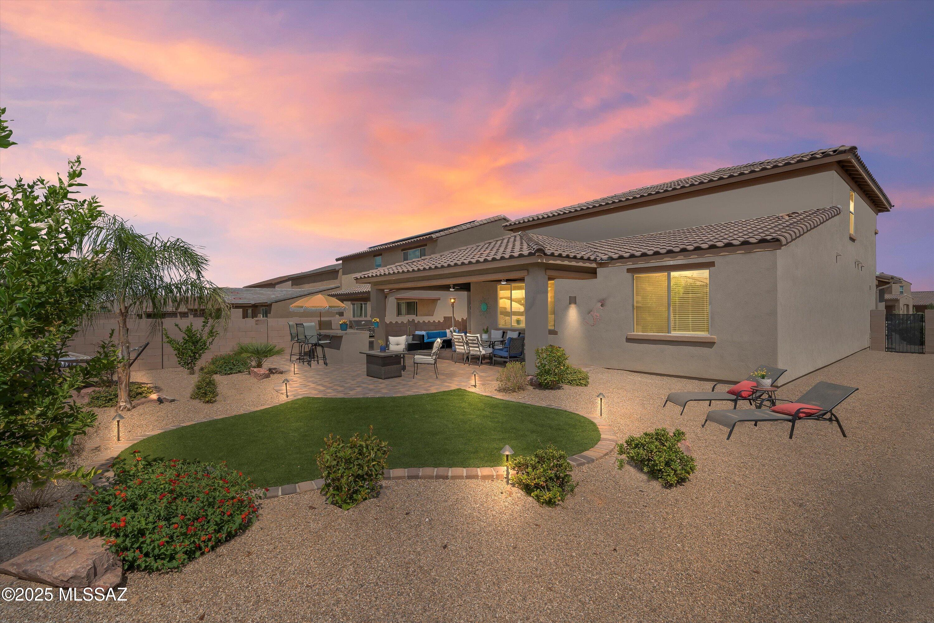 Beautiful, Private Backyard! Why buy new when you can enjoy all the extras right now? This stunning five-bedroom home offers the upgrades, extra storage and finishing touches that make a house truly move-in ready, with the added comfort of knowing the small details have already been taken care of. The backyard is the star of the show-beautifully landscaped and low maintenance, designed for both entertainment and everyday relaxation. Enjoy a built-in gas barbecue, beautiful seating and gathering spaces, an oversized covered patio, no rear neighbors, and an extra-high back wall that provides privacy and tranquility. It's a backyard built for fun, family, and at-home enjoyment. Located in one of Rancho Sahuarita's newer neighborhoods, you'll be steps from the Safari Trail, splash pad, pool, playgrounds, and basketball and volleyball courts, with all of the award-winning community amenities right at your fingertips. Inside, the home features a spacious and versatile layout. The primary suite is conveniently located downstairs for privacy, along with another full bedroom and bathroom, perfect for multigenerational living, teenagers, or guests. The kitchen boasts granite countertops, a gas stove, stainless steel appliances, ample cabinetry, and a generous walk-in pantry, opening to a bright dining and living area. A large laundry room adds practicality, while the open entryway makes an inviting first impression. Upstairs, a roomy loft provides flexible living space alongside three additional bedrooms, each well-sized, with walk-in closets in select rooms. The shared bathroom includes dual sinks, adding convenience for families of all sizes. Mountain views complete the picture, ensuring that every member of the household has the space and comfort they need. This home has it all... space, privacy, Storage, upgrades, and a backyard built for memories.