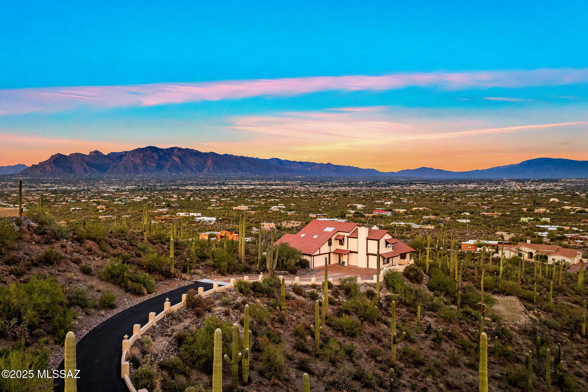Significant price reduction! 

Set on a hilltop lot within gated Sunset Hills Estates, this Tucson retreat offers panoramic, unobstructed city and mountain views across 1.4 saguaro-studded acres. 
Just minutes from Saguaro National Park, downtown, and the JW Marriott Starr Pass Resort, the property blends serene desert surroundings with convenient access to premier hiking, golf, dining, and resort amenities. 

Designed to capture the surrounding landscape, the home features hardwood floors and warm hardwood accents throughout, view-oriented windows that frame sweeping sunsets and sparkling city lights, and an expansive covered patio ideal for outdoor living. The home has an eat-in kitchen and a formal dining room. This home offers two living rooms, each with its own fireplace. Both the spacious Arizona room and living room with bar area showcase stunning views of downtown Tucson and the Catalina Mountains providing an inviting space to relax, work, or entertain.
The upper level includes a primary bedroom along with two guest bedrooms connected by a Jack-and-Jill bathroom.
The lower level features a separate studio, ideal for guests, extended family, a college student, home office, or creative space.

The property presents an excellent opportunity for new owners to personalize and update the home to suit their vision and lifestyle.

A rare opportunity to own a hilltop property with rare, true panoramic views of Tucson.  
Bonus: The roof remains under a transferable warranty.