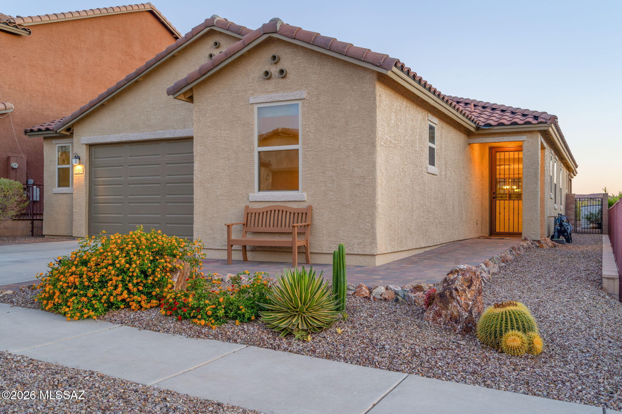 Perfect with Fully Owned Solar PV System makes this home extremely energy-efficient.  A desirable open-concept layout 3-bedroom split floor plan, plus den. The spacious great room and dining area flow seamlessly to a screened-in AZ Room with rolling shutters for shade and weather protection. The kitchen features quartz countertops, 42'' cabinets, a large island bar, stainless appliances, and pantry. Interior highlights include tile flooring with carpet in bedrooms, 9-ft ceilings, ceiling fans, and upgraded window coverings. Backing to natural desert common area, the landscaped yard offers shrubs, faux grass, and a paver patio with pergola for enjoying the the sunset and mountain views. OWNED SOLAR, two EV outlets, and extended garage with refrigerator included. Award winning Vail Schools!