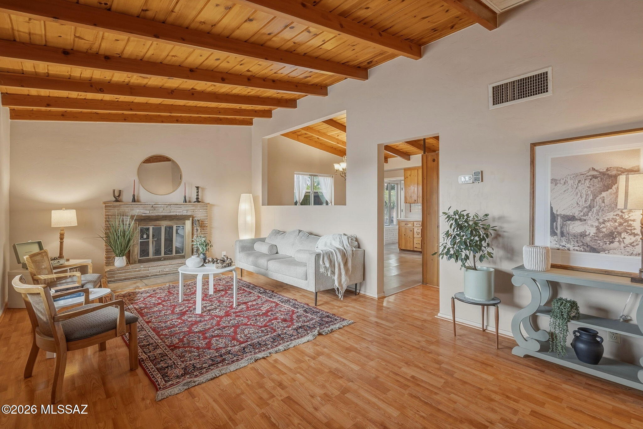 This desert retreat is a gardener's paradise. Abundant natural light floods the home allowing the pitched beamed ceiling to shine. The warmth of the wood provides a cozy ambience and a cohesion to every room. Warm and inviting with impeccably preserved midcentury charm that seamlessly blends modern touches. Featuring a stacked sandstone wood burning fireplace in the living room and beautiful knotty pine kitchen cabinetry with updated quartz countertops and newer stainless-steel appliances. Off the kitchen is the sunroom, a plant paradise with wall-to-wall windows, perfect for a second living room or an office. 

The expansive primary bedroom offers a large walk-in closet as well as a second closet, a seating area and an ensuite. The guest bathroom couldn't be more charming with pink and brown tile, knotty pine cabinetry and pitched beamed ceilings, in mint condition. The yard offers two fenced areas with fruit trees, herbs, produce, and a cactus garden. Walking distance to The Loop, Hop Shop, Brandi Fenton Park and the Botanical Gardens.   Come check out the midcentury charm for yourself!
