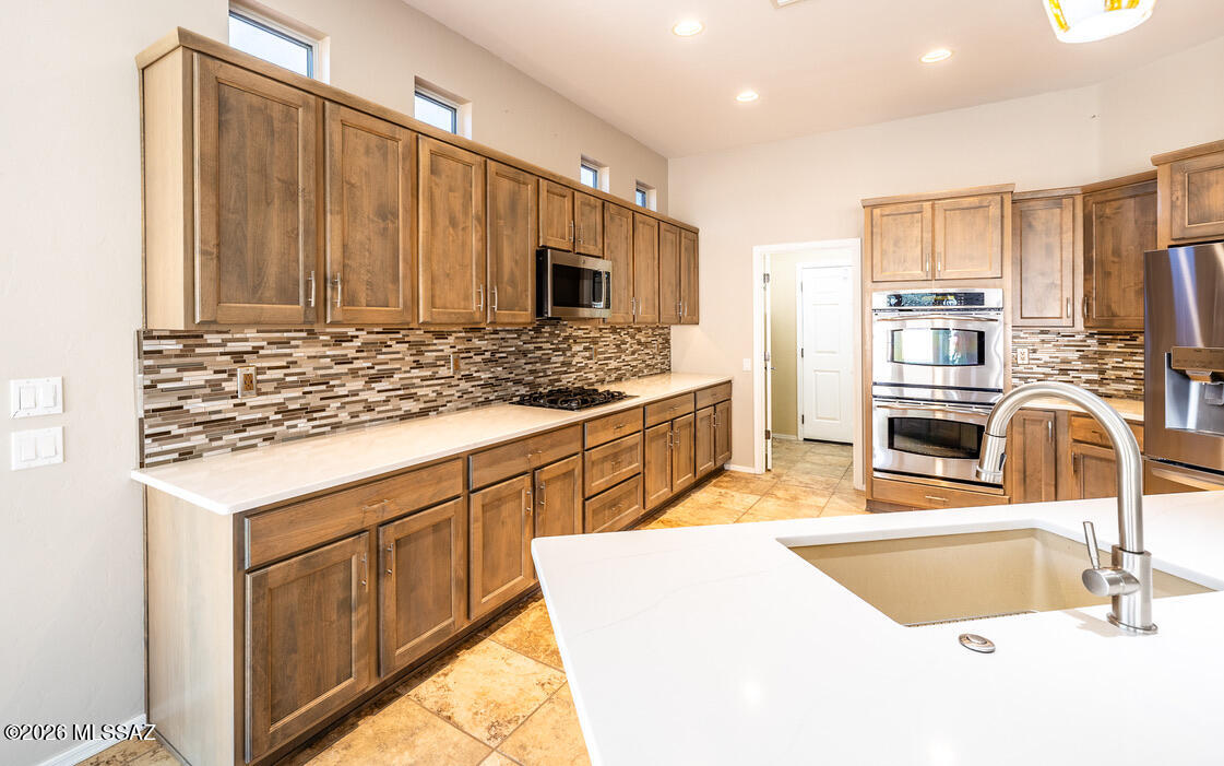 Very HIGHLY SOUGHT OUT AND UPGRADED SANTA ROSA. Great location near North Gate. Outstanding upgrades including Entertainer's Kitchen w/Quartz Countertops, Extended Wood Cabinetry, Quartz Topped Island and all SS Appliances Included. Spacious Family Room w/Gas Fireplace, Built-In Dry Bar, Media Inserts. DEN w/Double Doors & Built-In Desk. Large Owner's Suite w/Room For Any Size Bed, Bay Window, Large Walk-In Closet and Upgraded BATH w/ One of the Coolest Wrap Around & Tiled Showers. Guest Bedroom Suite w/Bedroom w/Bay Window and Upgraded BATH - w/Double Doors making it a true Suite. 2020 Sq Ft; 2BR/2BA + DEN, 2 Car Garage w/Golf Cart Space Push Out. Huge Covered Patio w/Sunshades leads to a delightful Backyard Oasis - Grilling Station, Lush Landscaping and Mountain Views.