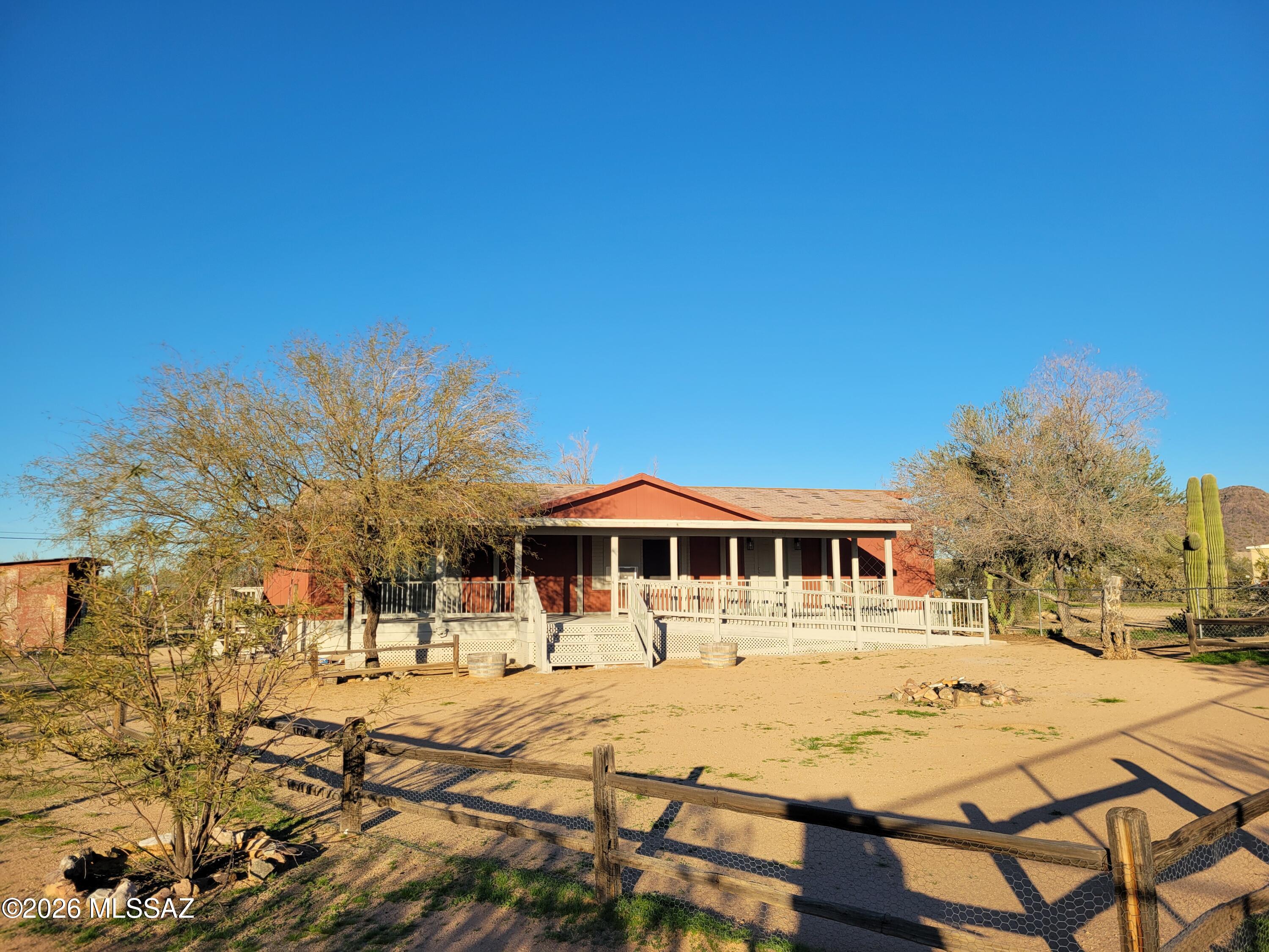 Rural living at its best! This manufactured home sits on 1.11 acres of beautiful desert land near Saguaro National Park West, offering easy access to outdoor adventures. Enjoy the convenience of nearby amenities including a convenience store, gas station, eateries, Dollar Tree &more.  The home features 3 bedrooms plus a den/office, 2 bathrooms & a kitchen open to the living room. A large back porch provides the perfect space to relax and take in the surrounding desert views. Several fresh updates have been completed, including a newer HVAC system. Seller to install a new roof prior to closing with an acceptable offer, call for details.  Your next desert adventure starts here. Schedule your private showing today. Cash OR Specialized Loan, call for details. No Conventional, FHA or VA loans.
