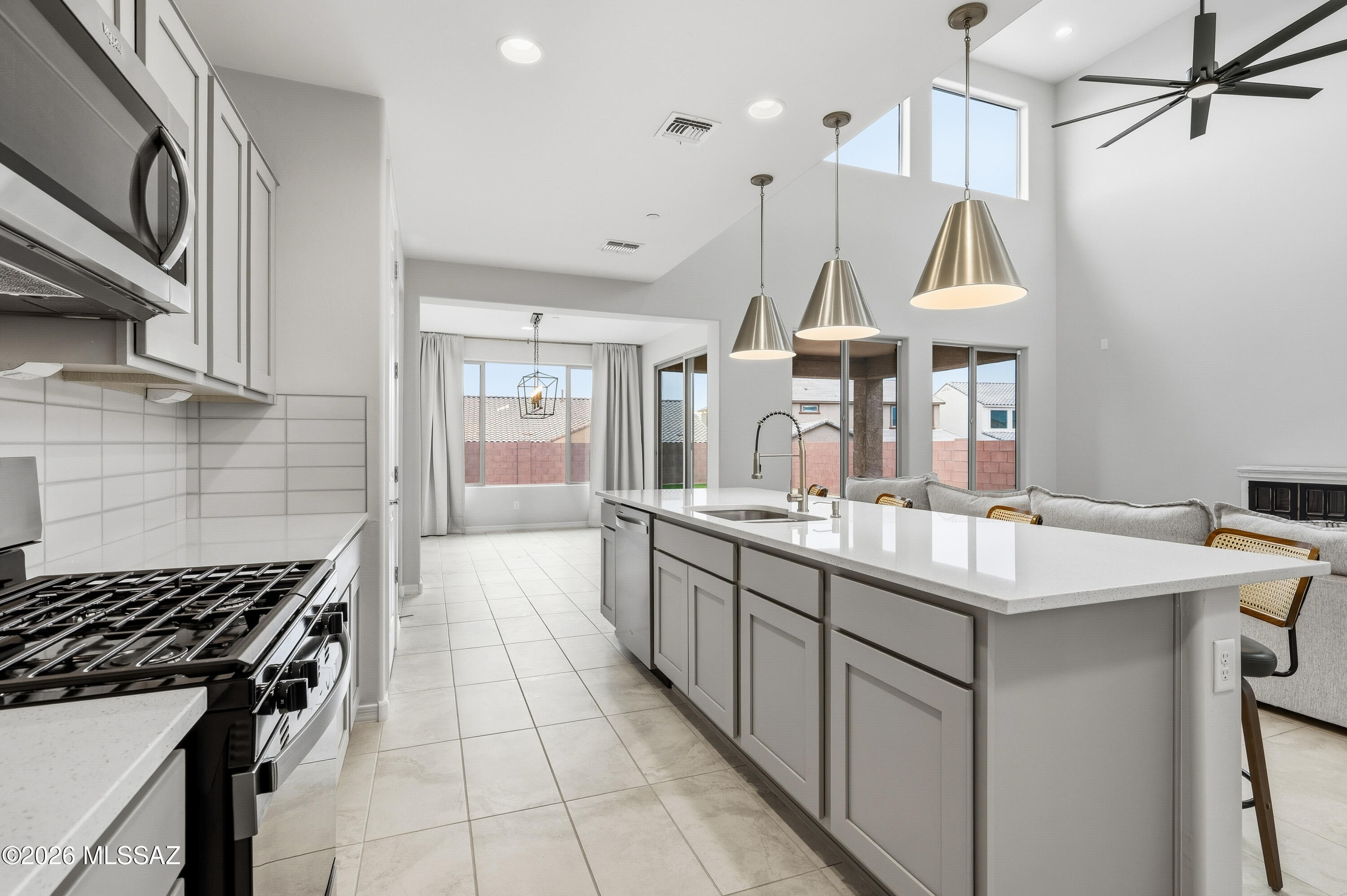 VA ASSUMABLE LOAN AVAILABLE! Welcome to this exceptional home that blends comfort, design, and lifestyle in a premier location. This spacious 4 bedroom, 3 bathroom residence in the highly sought after Rocking K community offers a thoughtfully designed layout with a downstairs primary suite and three additional bedrooms upstairs, including a private en suite that is ideal for multi generational living or guest privacy. The heart of the home is a large open concept kitchen, living, and dining area that creates an inviting space for everyday living and entertaining. The well designed kitchen features stainless steel appliances, a stylish tile backsplash, quartz countertops, and abundant grey cabinetry that provides both function and modern appeal. Additional upgrades include a tankless water heater and a water softener for enhanced comfort and efficiency. Step outside to a beautifully finished backyard designed for low maintenance enjoyment year round. The outdoor space includes artificial turf, paver hardscaping, mountain views, and plenty of room to relax, gather, or play. Located in one of Tucson's most desirable master planned communities, residents of Rocking K enjoy access to a stunning community park with pickleball courts, walking and biking trails, a water splash pad, and close proximity to award winning Vail School District schools, consistently recognized as one of the top rated districts in the region
