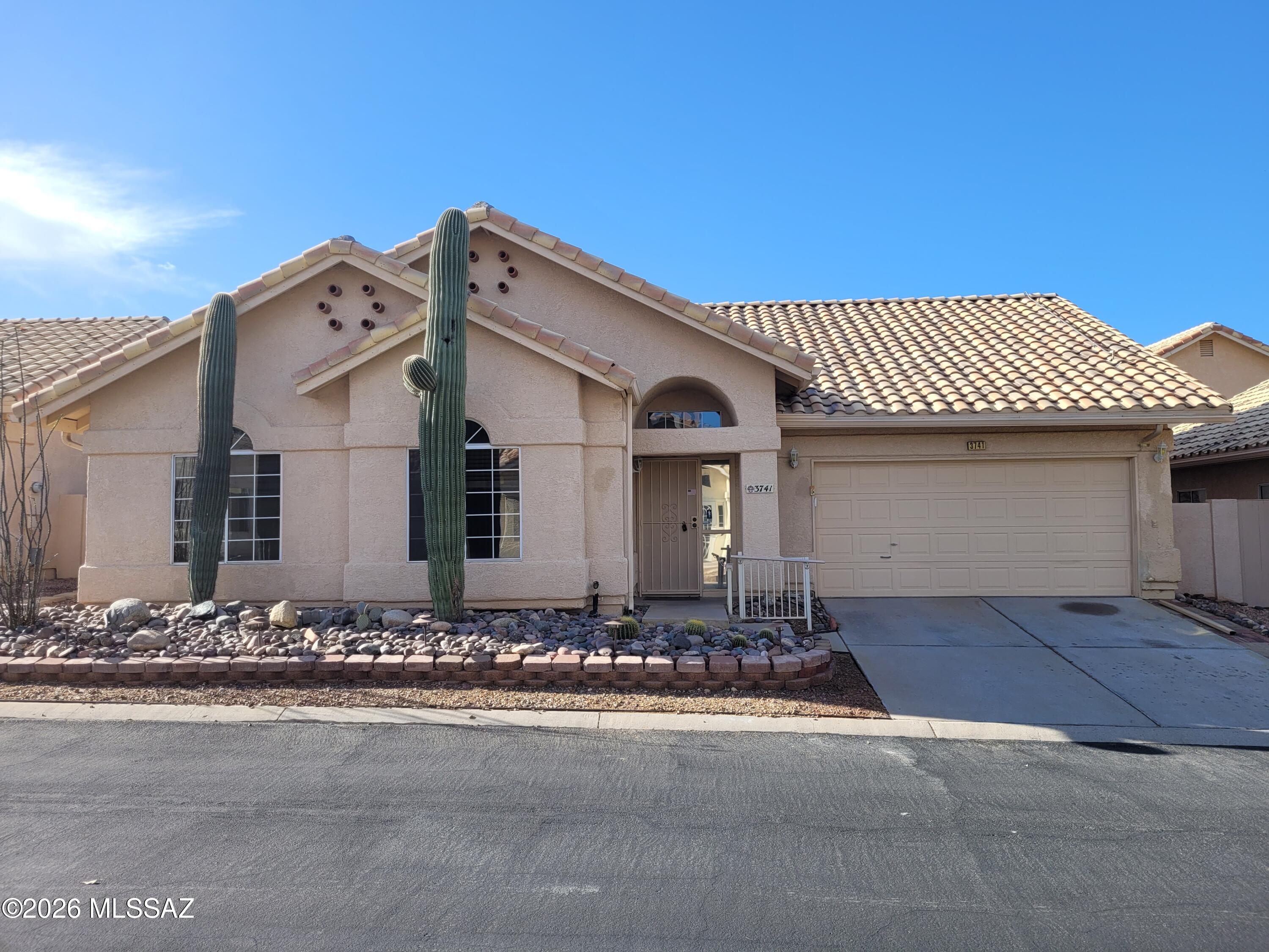 Beautiful 3-bedroom, 2-bath home in Northwest Tucson featuring solar panels for added energy efficiency & lower utility costs. Spacious floor plan offers a neutral color palette & numerous upgrades throughout. The open great room design is complemented by ceramic tile flooring in main living areas, wood flooring in primary suite, & newer carpet in the secondary bedrooms. Well-appointed kitchen features raised-panel cabinetry, granite countertops, stainless appliances, & breakfast bar overlooking the adjacent dining area. Step outside to a low-maintenance backyard complete w/artificial turf & covered patio, providing the ideal space to relax & enjoy. Additional amenities include central A/C, a 2-car garage, and reduced electric bills thanks to the solar system.