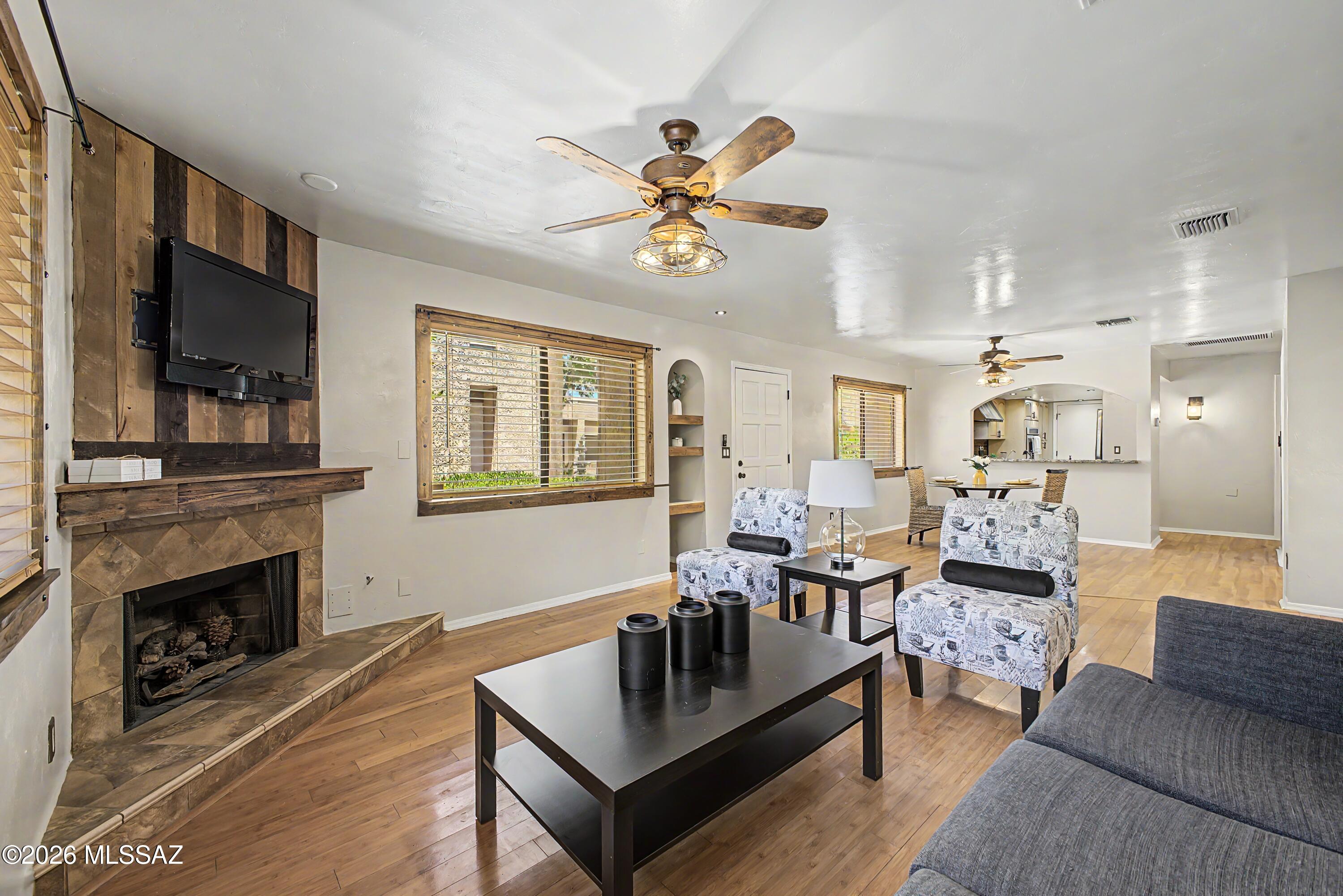Move-in-ready single-level home in the desirable La Fontana community offering comfort & low-maintenance living. New laminate & existing real wood flooring add warmth & style throughout. Spacious primary suite features a remodeled custom-tiled shower, granite countertops, & a large walk-in closet with built-ins. Versatile den is perfect for an office, guest room, or extra living space. Updated kitchen includes granite counters, stainless steel appliances, recessed lighting, & opens to the main living area. Enjoy a private covered patio with mature landscaping. Community amenities include a pool, spa, and park-like grounds. Additional features include a spacious garage with built-in storage & a utility sink. Conveniently located near the UofA, hospitals, shopping, dining & downtown Tucson.