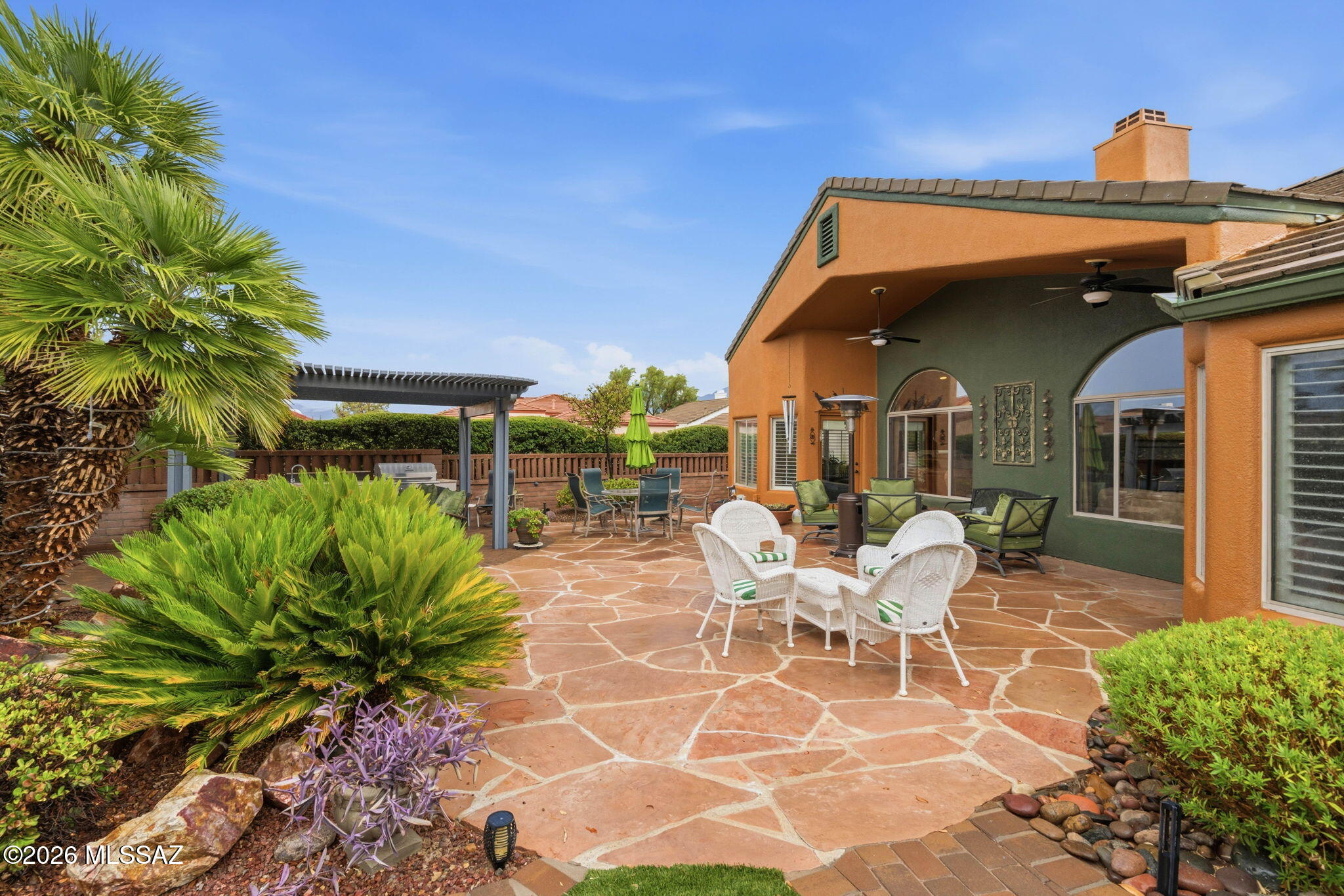 MUST SEE!!!This gorgeous contemporary home sits upon a courner lot with southwest aesthetics true to the region. Approach a pristinely manicured entry with hand-crafted custom artwork, and enter into the BEAUTIFUL DETAIL AND FINISHES of the interior with stone couter tops throughout, a magnificent two-way fireplace. stone-tiled bathrooms and elegant furnishings. The backyard is a true slice of paradise with beautiful landscaping, a pergola-covered outdoor kitchen, water feature, and privacy! The Greens at Santa Rita is a gated community which has its own private pool, as well as access to all the Green Valley amenities such as the gym, club house, tennis courts, and golf. This home can be sold furnished, or cleared out to the buyers preference. DON'T MISS OUT on this great opportunity.