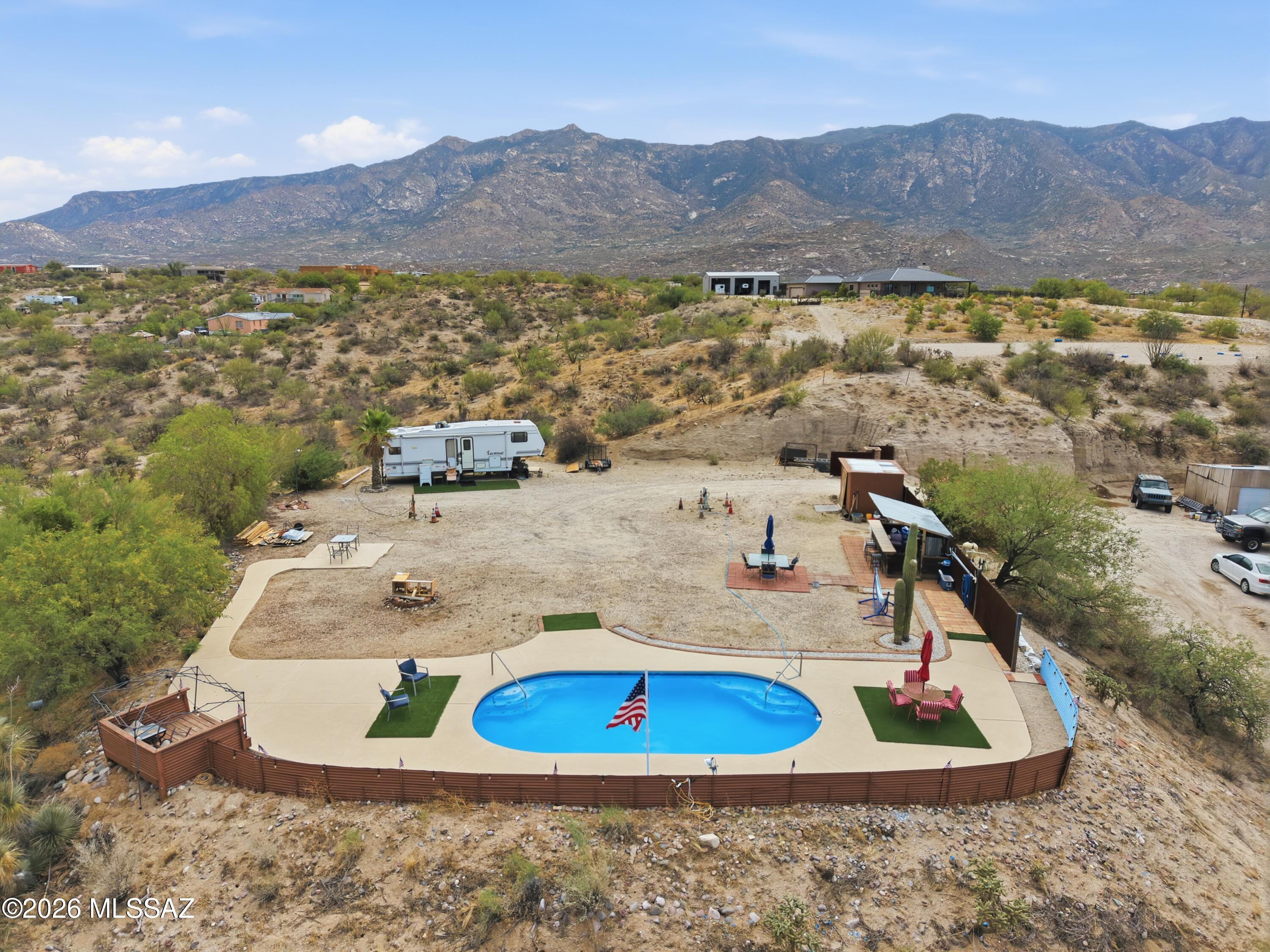 Private scenic homesite at the end of a quiet road w/ sweeping views & privacy. Enjoy country living while remaining close to everyday conveniences. Adjacent access to state land & nearby hiking trails makes this an ideal location. A custom Southwest-style metal entry gate, decorative brick & block pillars & matching metal fencing creates an attractive entrance & added character. The property is ready for your custom home w/ an existing septic system, utilities on site & a pool already in place. The lot features four RV hookups w/ electric, water & septic connections. Peaceful setting w/ endless possibilities for a primary residence, vacation getaway or investment opportunity. Tenant occupied. Do not enter property without an appointment. Minimum 48-hour notice required for all showings.