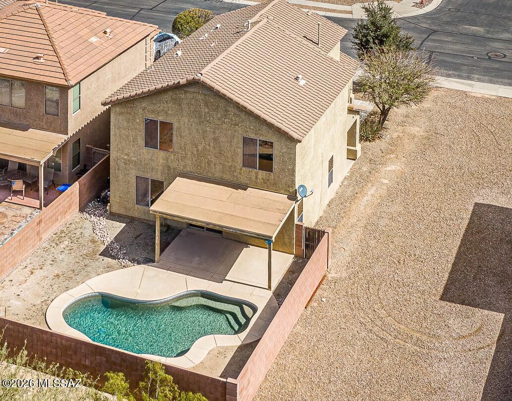 Experience the ultimate RESORT LIFESTYLE in this wonderful 5-bedroom, 3-bathroom plus loft home complete with a SPARKLING POOL that is ready for you! Located on a premium lot with no direct neighbor behind and open space on one side, this can be your retreat from the modern world. You'll immediately fall in love with the light and bright open floor plan that flows seamlessly from the living space with tile flooring, to the dining area and kitchen. The kitchen has beautiful granite counter space and ample cabinetry, a pantry closet, stainless steel appliances, and a breakfast bar that is perfect for enjoying your morning coffee. The main level includes a full bedroom and bathroom--ideal for guests or multi-generational living. Upstairs, you'll find a generous loft perfect for a home office, media room, or gaming space, along with a spacious owner's suite and three additional bedrooms offering room for everyone. A dedicated laundry room with washer and dryer included adds everyday convenience, and ceiling fans enhance comfort year-round. Step outside and embrace true Arizona living. Your private backyard oasis features a sparkling pool and covered porch--perfect for relaxing, entertaining, or soaking up those beautiful desert evenings. The community park is just a short distance away and comes with walking trails, ramadas, BBQs, a grass field, and even a basketball court! And thanks to its convenient location just minutes from shopping, restaurants, and I-19, you'll be able to enjoy all the best that the area has to offer. With a low HOA fee of only $110 per quarter, this home is an incredible value. So why wait? Come and see it for yourself today and experience the vacation vibes every day!