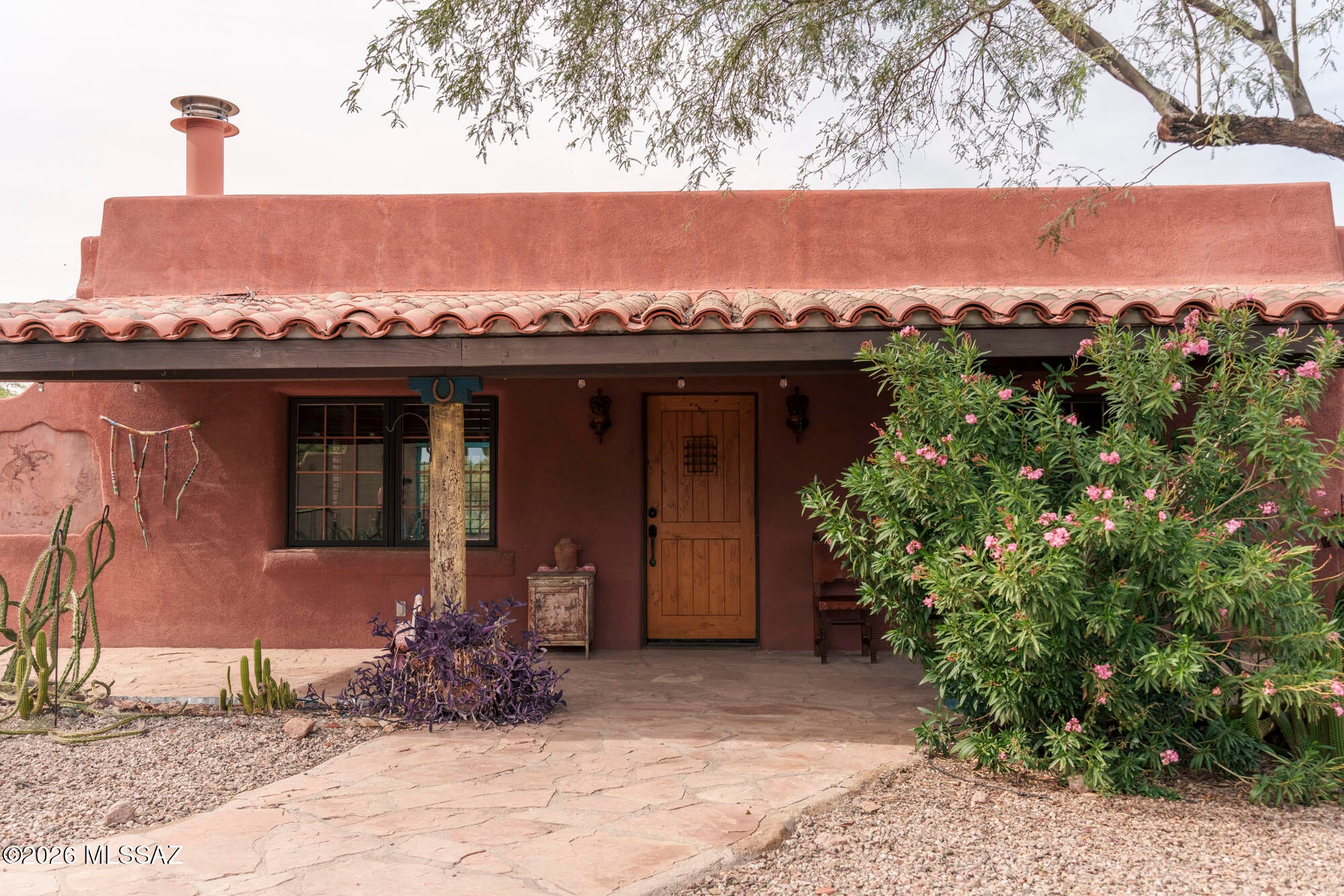 At the base of Safford Peak, where the desert brushes up against the edge of Saguaro National Park, a gravel road leads you through the old Black Arrow Lodge entrance past large, private parcels, deeper into land. Near the end of that road, tucked to the right, you'll find 7943 West Pima Farms Rd, which is one of four adobe guest houses that was ones part of the known Black Arrow Lodge built in 1949. The home sits on over three-acre and the 672-square-foot adobe home was fully renovated in 2004 with an extra 288 sqft Arizona room -- wood beam ceilings overhead, Mexican tile in the kitchen and main bathroom, and French doors that open from the main house into the Arizona room. Outside, lush desert landscaping frames a patio with sweeping, unobstructed views of Safford Peak. In 2021, a 314-square-foot casita and studio was added -- room for guests, or a quiet space for arts and crafts. The home also have newer HVAC, water heater, water softener, cook-top and oven. A detached garage and storage round out the property. Seventy-seven years after that first arrow gave this land its name, 7943 West Pima Farms Road still feels less like a house, and more like a place with a story still being written.