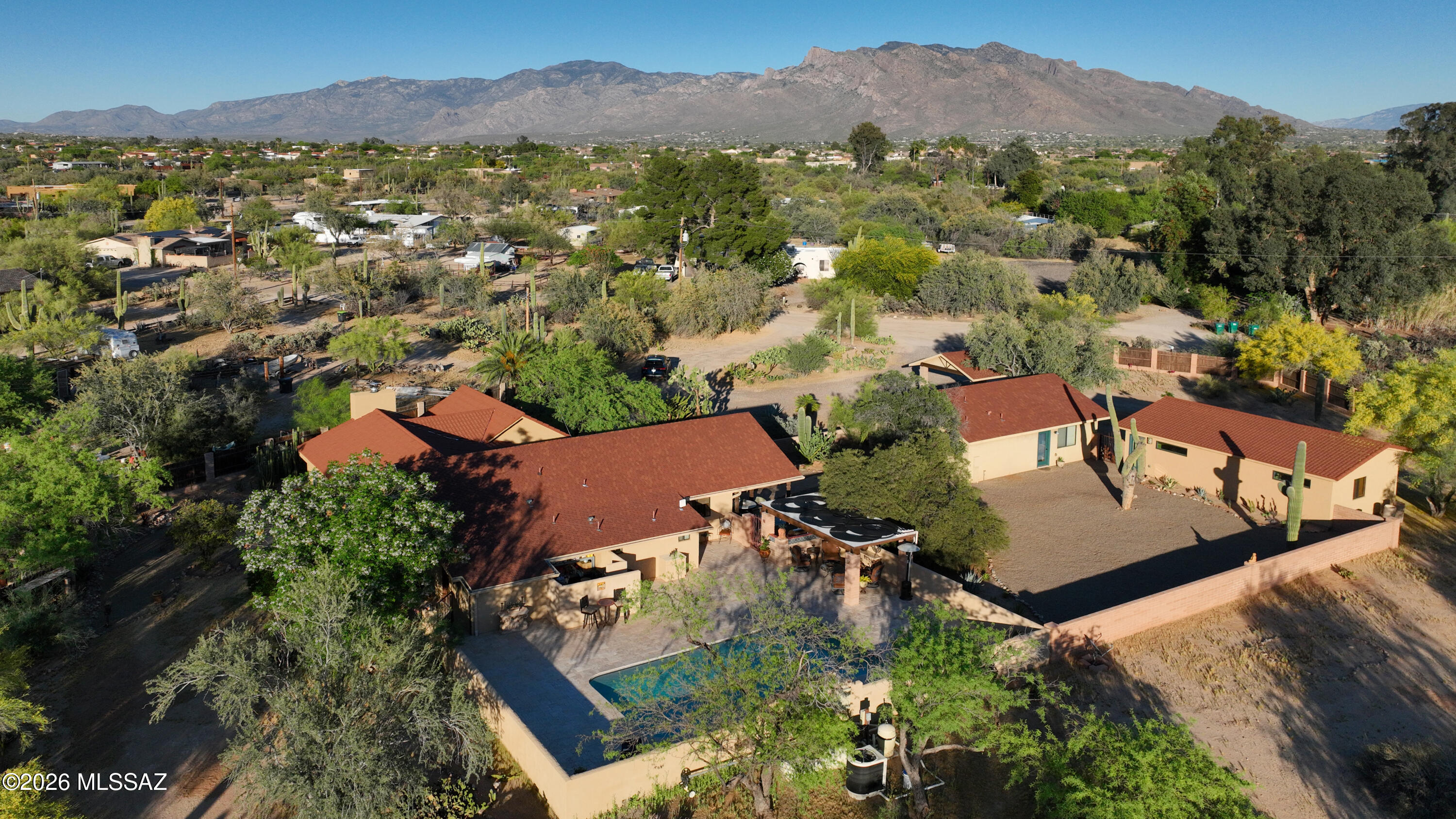 Rustic SW retreat provides country living in the heart of NW Tucson! Secluded, private, serene oasis offers 3034 SF living space including a 2298 SF main home and 736 SF guest house. Ideal for multi-generational living or a rental revenue stream Airbnb type property. Main residence offers 3 BR/3BA loaded with rustic SW charm plus a 2 BR/1BA guest home.  Warm & inviting but stacked with elegant features including: wood burning fireplace w/air induction system & beamed ceiling, custom entry doors & Mexican tile floors. Gourmet kitchen featuring custom mesquite cabinetry, granite counters & stainless Electrolux appliances.  Outdoor entertaining with covered patio, gazebo, pool & built-in BBQ. Ample parking w/2 car garage, 2 car carport, shop w/sauna. Zoned for 2 horses and so much more!