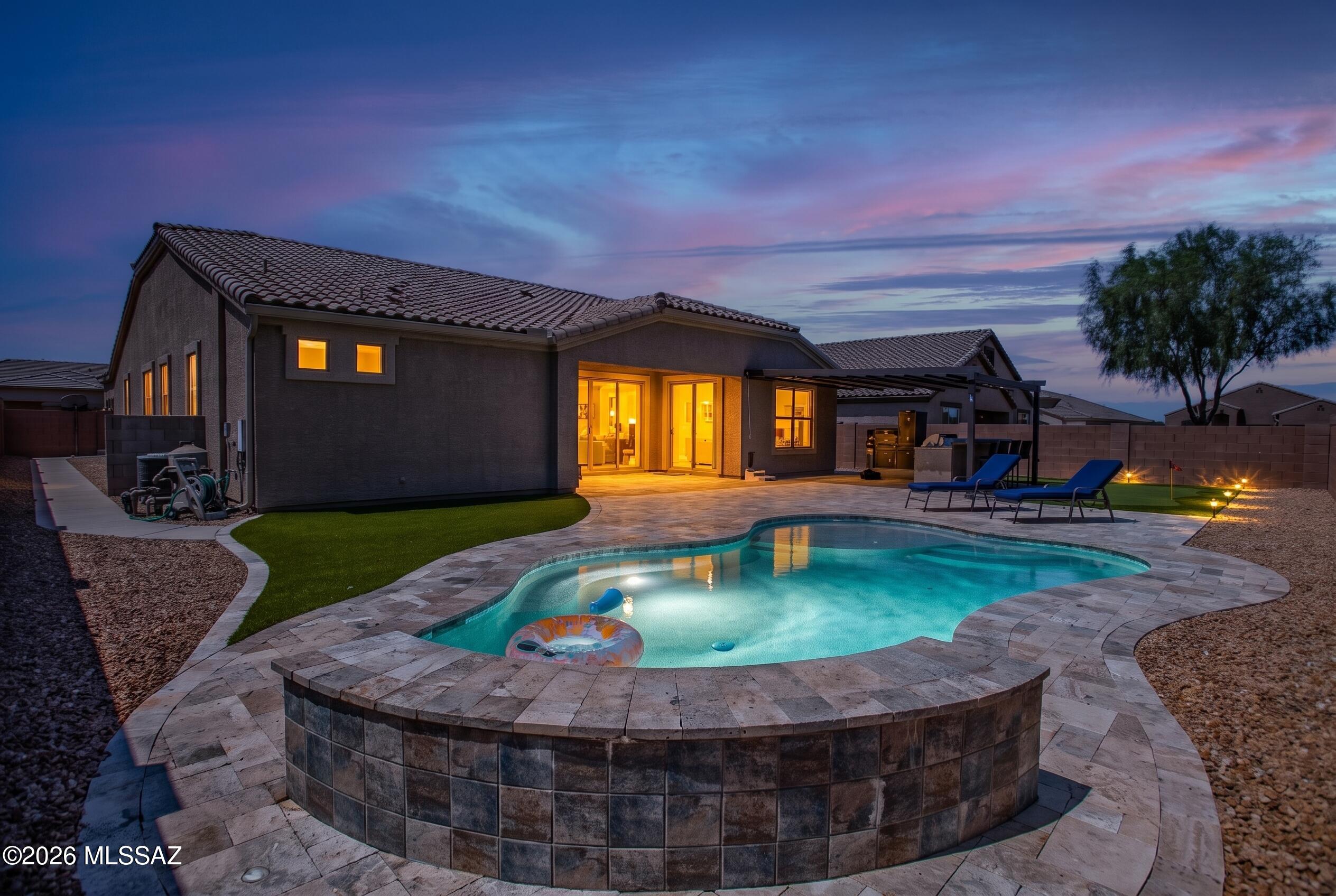 VERY LOW ASSUMABLE RATE! This beautifully upgraded 1-story home offers 4 bed 1 den 3 baths 3-car garage. The open floorplan features soaring ceiling & tons of natural light. Gorgeous gourmet kitchen features oversized island, granite countertops, staggered birch cabinetry, stainless steel appliances, gas cooktop, double ovens & walk-in pantry. The luxurious primary suite offers dual vanities, large tiled walk-in shower & spacious walk-in closet. Absolutely amazing resort-style backyard offers travertine pavers, covered pergola w/retractable waterproof awning cover, built-in gas smoker BBQ, dining bar, sparkling pebble tec pool, waterfall, putting green. Private lot backing to a wash w/mountain view. Minutes to I-10, schools, shopping, dining & entertainments. Solar system is a huge saving!