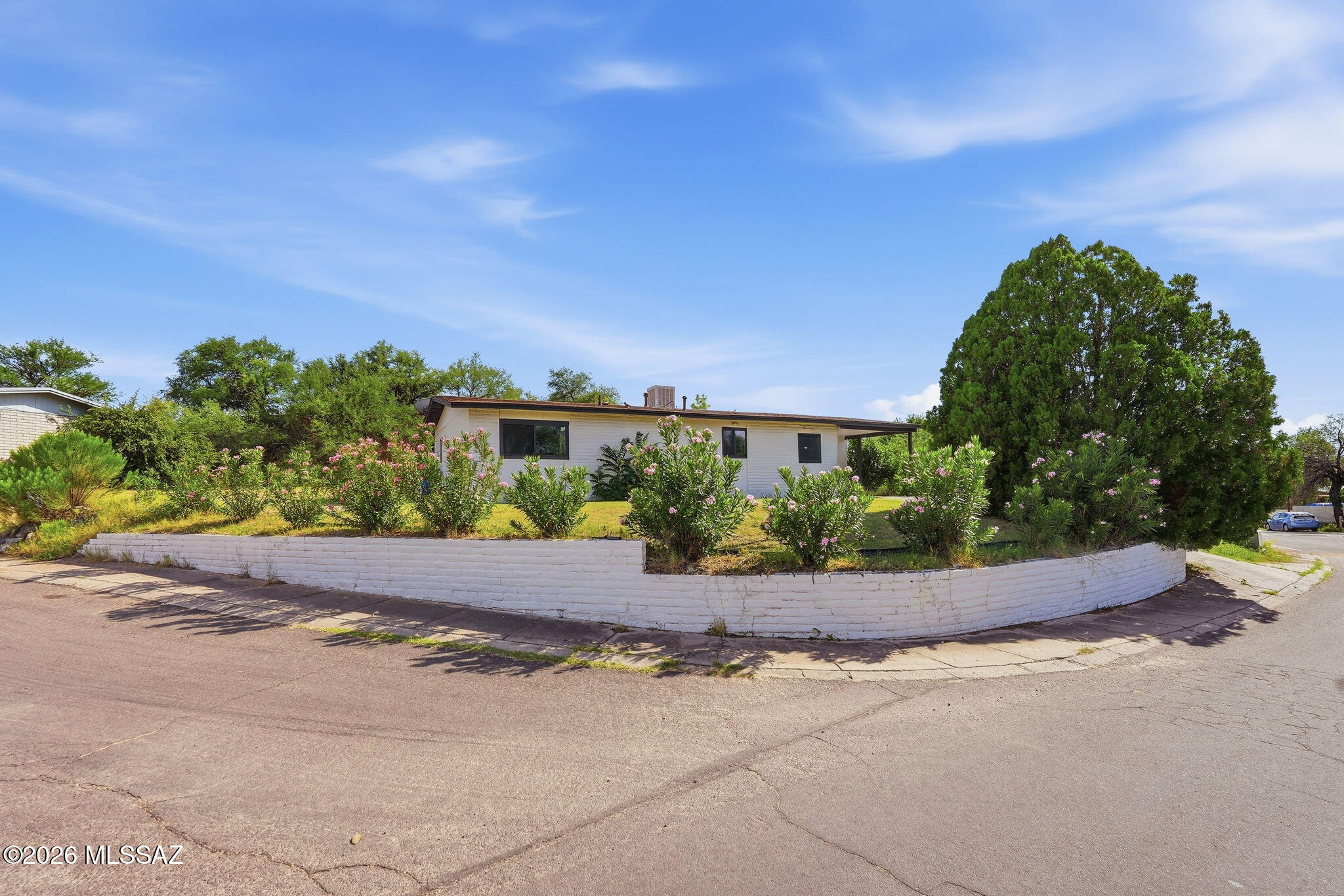 Thoughtfully maintained and full of character, this warm and welcoming 3-bedroom, 2-bath home offers comfortable single-level living on a spacious 0.27-acre lot in Nogales' Monte Carlo Estates. Freshly painted inside and out, the home features an open layout with wood-look flooring, painted brick accents, abundant natural light, and a generous breakfast bar that creates a natural gathering place between the kitchen and living areas. A versatile bonus room with a fireplace adds warmth and flexibility, making it ideal as a family room, game room, home office, hobby room, or den.

The kitchen offers ample cabinetry, stainless steel appliances, generous counter space, and a functional design that makes everyday living easy. Large sliding glass doors connect the living space to an expansive covered patio, creating a seamless indoor-outdoor flow ideal for relaxing, entertaining, or enjoying Nogales' beautiful weather.

The spacious backyard is framed by mature trees and offers plenty of room for gardening, outdoor recreation, pets, or future customization. A detached storage building provides added flexibility for hobbies, tools, or seasonal storage.

Conveniently located near Monte Carlo Trails, local schools, shopping, dining, and everyday conveniences, this property offers generous outdoor space, flexible living areas, and the comfort of a home that has been thoughtfully cared for over the years.