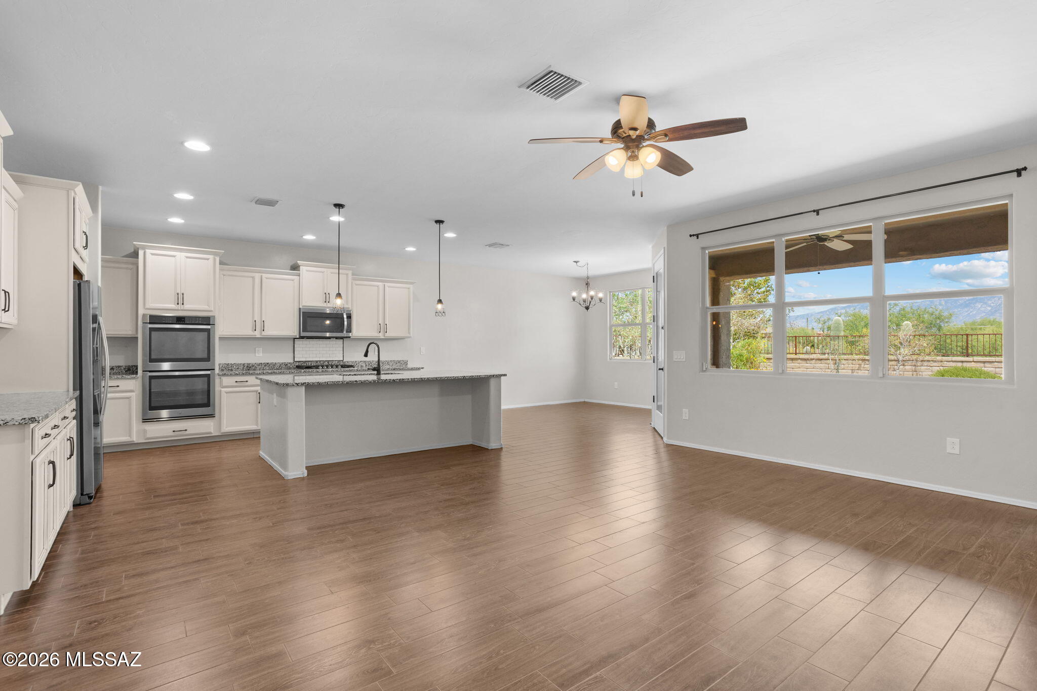 Wake up to stunning views of the Catalinas. Wind down the same way. This Oro Valley home was built for the way people actually live, mornings with coffee in a sun-washed east-facing beautiful landscaped backyard, dinner parties that flow naturally from a gourmet kitchen into formal dining, and lazy Sundays with mountain views framed in every window of the great room and kitchen. 

The kitchen is the heart of it: a large center island, 6-burner gas cooktop, double ovens, brand new dishwasher, extended staggered cabinetry.and the kind of counter space that makes cooking feel effortless rather than crowded. The formal dining room, with its tray ceiling and butler's pantry pass-through, is built for the kind of dinner that lingers. The primary suite is a genuine retreat: soaking tub, separate shower, double vanities, private toilet room, and a walk-in closet lined with compressed cedar providing moth repellent and moisture absorbing benefits. . The split floor plan keeps guests comfortable and the household sane. Every room has a ceiling fan, a small thing that matters a lot in an Arizona summer. Three additional bedrooms, three full bathrooms, a huge laundry room with utility sink, and a three-car tandem garage with built-in storage round out a home that has thought through the details: custom iron security door, water conditioner, fresh paint throughout, new bedroom carpet, tray ceilings with recessed lighting, and removable privacy film on key windows. 

Outside the front door, Rancho de Plata delivers parks, trails, and direct walking access to Wilson K-8. Ironwood High School, Leman Academy, Casas Adobes, and Basis Oro Valley, one of the consistently top-ranked high schools in the country, are all nearby.

Some homes you tour. This one you start picturing your file in.