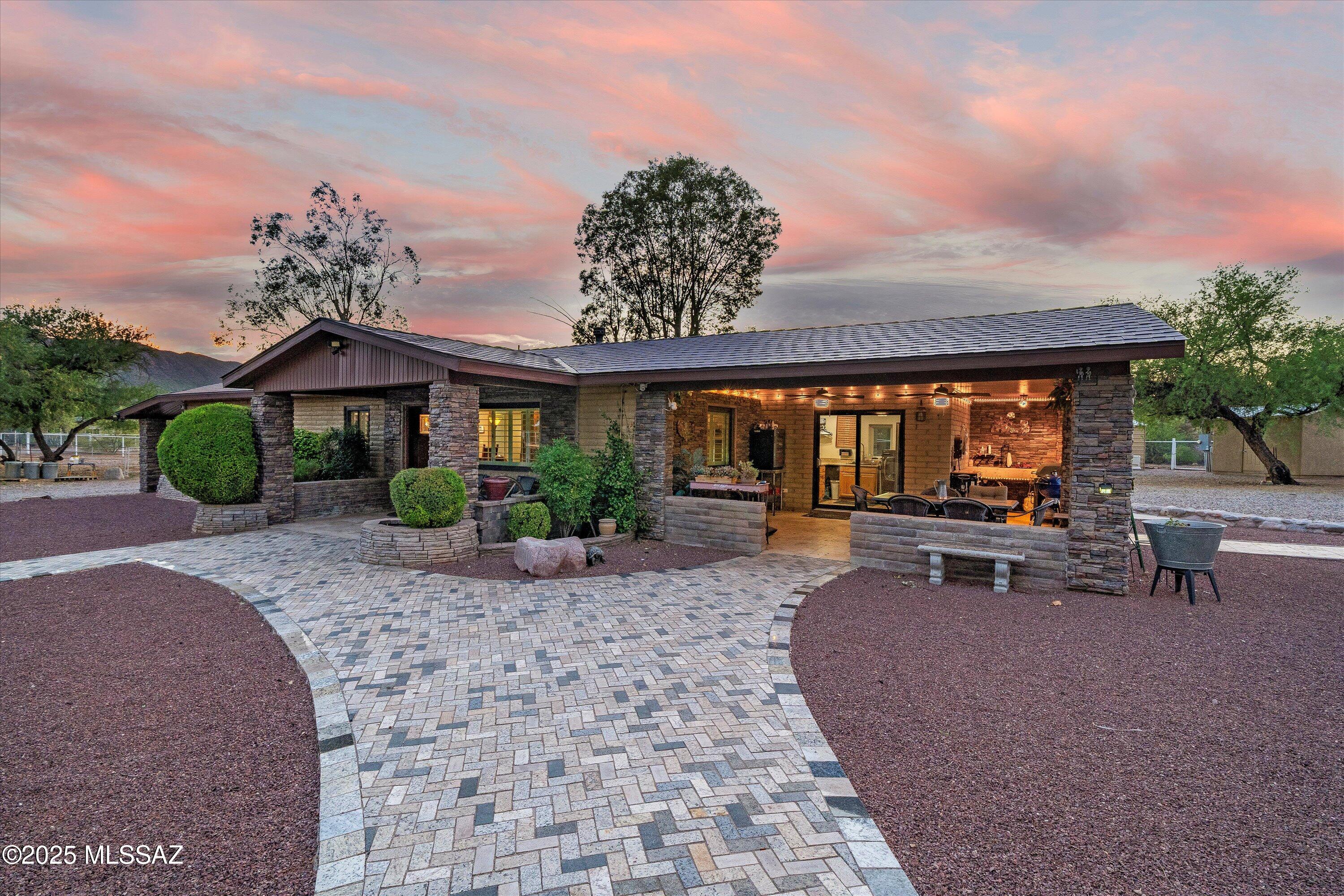 5.74 acre ranchette horse property in Aravaipa, with private access to miles of BLM and state land. Enjoy the year-round running creek, out the back gates! Complete equestrian training set up, with LED-lit team roping area, barns, multiple fenced/shaded paddocks, and enough storage for 1.5+ semi-loads of hay. This meticously maintained property is completely fenced and gated, with video surveillance for security. Generac propane generator along with a private well allow you to continue living normally during a power outage, with the potential for offgrid living. The impressive block home features a 50 year rated metal roof, new Renewal by Anderson windows, recently installed dual unit HVAC system, and premium finishes: granite countertops, stainless appliances, custom knotty alder soft close cabinetry, custom rock fireplace, and tile flooring throughout. Primary bathroom features soaking tub and separate shower, with intricate tile surrounds. Huge primary walk-in closet with custom shelving and two wall safes. The off-kitchen laundry room features additional storage cabinets, an upright freezer, and large sink. Relax in the covered outdoor kitchen area, with sink and grill. The expansive acreage features 9 carport bays, drip irrigation/ 20+ hose bibs for watering, a private workshop with wood-burning stove, along with multiple outbuildings and a tremendous amount of storage.  The productive private well has a 1500 gallon tank with recently replaced booster and well pumps. Home features Ecowater softener/filtration system, along with RO at sink for drinking water. Stone and block main entrance features designer custom gates, and home is surrounded by travertine walkways/patios. Corrals use schedule 40 and schedule 80 piping, along with welded wire fencing. Enjoy rural living and incredible mountain views, only 40 minutes from Oro Valley. No HOA! Property uses a Winkelman/Dudleyville zip code, but is located in the Aravaipa canyon area.