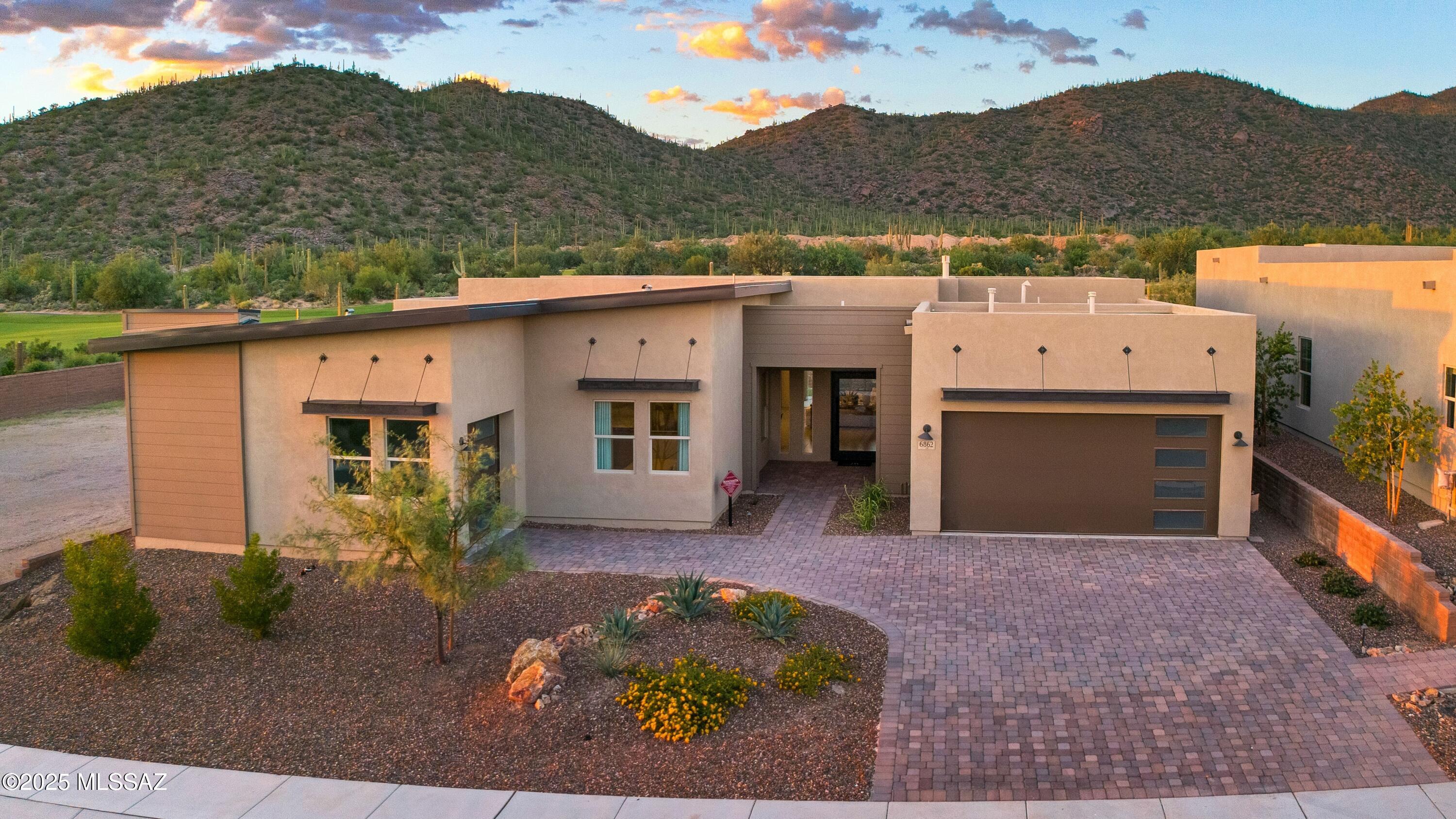 Absolutely Spectacular Former Model in Boulder Bridge Pass. Built by the prestigious Fairfield Homes, this move-in-ready masterpiece is perfectly sited on a spacious homesite with unobstructed views of the lush Dove Mountain golf course and the saguaro-studded Tortolita Mountains. A sleek pivot door sets the tone for 12-foot ceilings, clean architectural lines, and a gas fireplace that anchors the great room. Expansive 16' x 10' multi-slide glass doors blur the line between indoors and out, opening to a fully landscaped backyard designed for effortless desert living.
The true gourmet kitchen is open to the great room and showcases custom cabinetry, designer tile backsplash, expansive quartz counters and island, premium stainless-steel appliances, a walk-in pantry, and exquisite pendant lighting.

The sought-after Manzanita model offers multiple flexible spaces, including a lounge/teen room, game room, or dedicated office. Three private guest suites, each with its own en-suite bath and walk-in closet, provide comfort and privacy for family and visitors.

The spacious primary suite is a true sanctuary, perfectly oriented to capture mountain and golf course views. The spa-like bath includes split dual vanities, a fully tiled walk-in shower, and sophisticated fixtures and finishes. An oversized custom closet with direct laundry access elevates everyday convenience.

A covered wrap-around patio invites year-round entertaining and relaxation. The backyard is thoughtfully designed with low-maintenance artificial turf, offering privacy and endless Sonoran Desert vistas.

Split three-car garage providing excellent storage and flexibility and premium finishes and meticulous attention to detail throughout.
This residence perfectly blends modern elegance with the tranquility of the desert. Don't miss the opportunity to own one of Dove Mountain's most impressive former model homes.