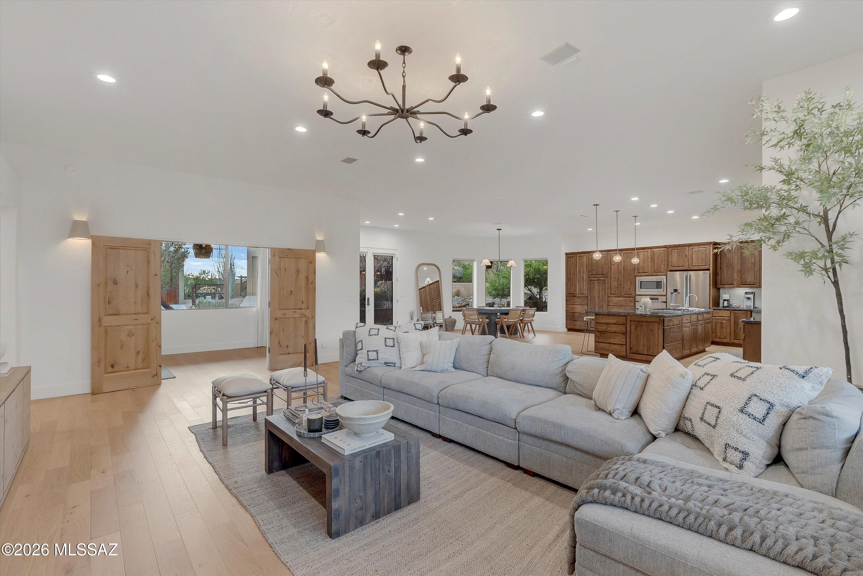 This is more than a home--it is a statement of quality, comfort, and elevated desert luxury at the base of the Tucson Mountains! Presenting a rare opportunity to own one of the most distinguished residences in Tucson Estates, masterfully built by renowned craftsman John Herder. Perfectly positioned on a premier cul-de-sac lot backing to protected open space, this exceptional property captures sweeping, unobstructed views of the majestic Tucson Mountains and the surrounding Sonoran Desert landscape.
Encompassing  2,724 total sq ft this thoughtfully designed Home offers 3 bedrooms and 2 bathrooms, plus a den/media room- designed to also function beautifully as a 3rd bedroom. In addition, the attached private studio-style Guest Quarters, complete with its own entry, and flexible open Bedroom/living space PLUS full bath offers exceptional adaptability as luxurious quarters, a refined home office, or an executive retreat.
Guest quarters also has an additional back entry door with direct patio access for full outdoor enjoyment!
Inside, sophisticated desert elegance meets superior craftsmanship. High-quality engineered Hardwood flooring flows seamlessly throughout, complementing solid wood interior doors and rich knotty alder cabinetry against the fresh bright interior. Your chef's kitchen is both striking and functional, showcasing chiseled-edge granite slab countertops, an island with bar seating, a stylish tile backsplash, a vegetable sink with disposal, and premium stainless steel appliances including a professional-grade refrigerator and Dacor oven with warming drawer.
An airy Great room designed for both grand entertaining and intimate evenings provides a modern open-concept living space. Featuring expansive windows that frame breathtaking mountain vistas. Natural light pours into the adjacent dining area, creating a warm yet sophisticated ambiance. Unique chandeliers elevate the spaces and provide a sense of distinction.
Your primary suite offers direct patio access, inviting tranquil mornings and sunset evenings against a dramatic desert backdrop. Primary ensuite complete with Travertine shower and spacious walk-in closet.
A gorgeous, fully remodeled hall bath completes the spaces.
Outdoor living is equally impressive! The northeast-facing rear yard is designed for year-round enjoyment, featuring an expansive covered patio, built-in gas fireplace, custom wrought iron view fencing, and uninterrupted views across protected nature. - Cat Mountain is just off to the right! This is Arizona living at its finest- private, peaceful, and picturesque.
Additional enhancements include new floors, 4" baseboards, interior paint, updated bathrooms, counters and backsplashes, lights fixtures, custom Roman shades, a new main house AC (2022), water softener, insulated garage doors, extensive lighting, decorative metal screen doors, and rear rain gutter system.
Residents enjoy resort-like living within this upscale gated community, including access to pool and spa facilities, Pickleball courts, clubhouse amenities, and the beautifully maintained Tucson Estates Golf Course. HOA also provides secured RV parking(based on availability). Just moments away, the extensive trail system of Tucson Mountain Park/Gates Pass offers miles of hiking, biking, and breathtaking desert exploration. Mountain View trail is just right off the cul-de-sac! Close proximity to Old Tucson, AZ Sonoran Desert Museum, Saguaro National Park West plus easy access to Ajo Hwy, I-19 & I-10.