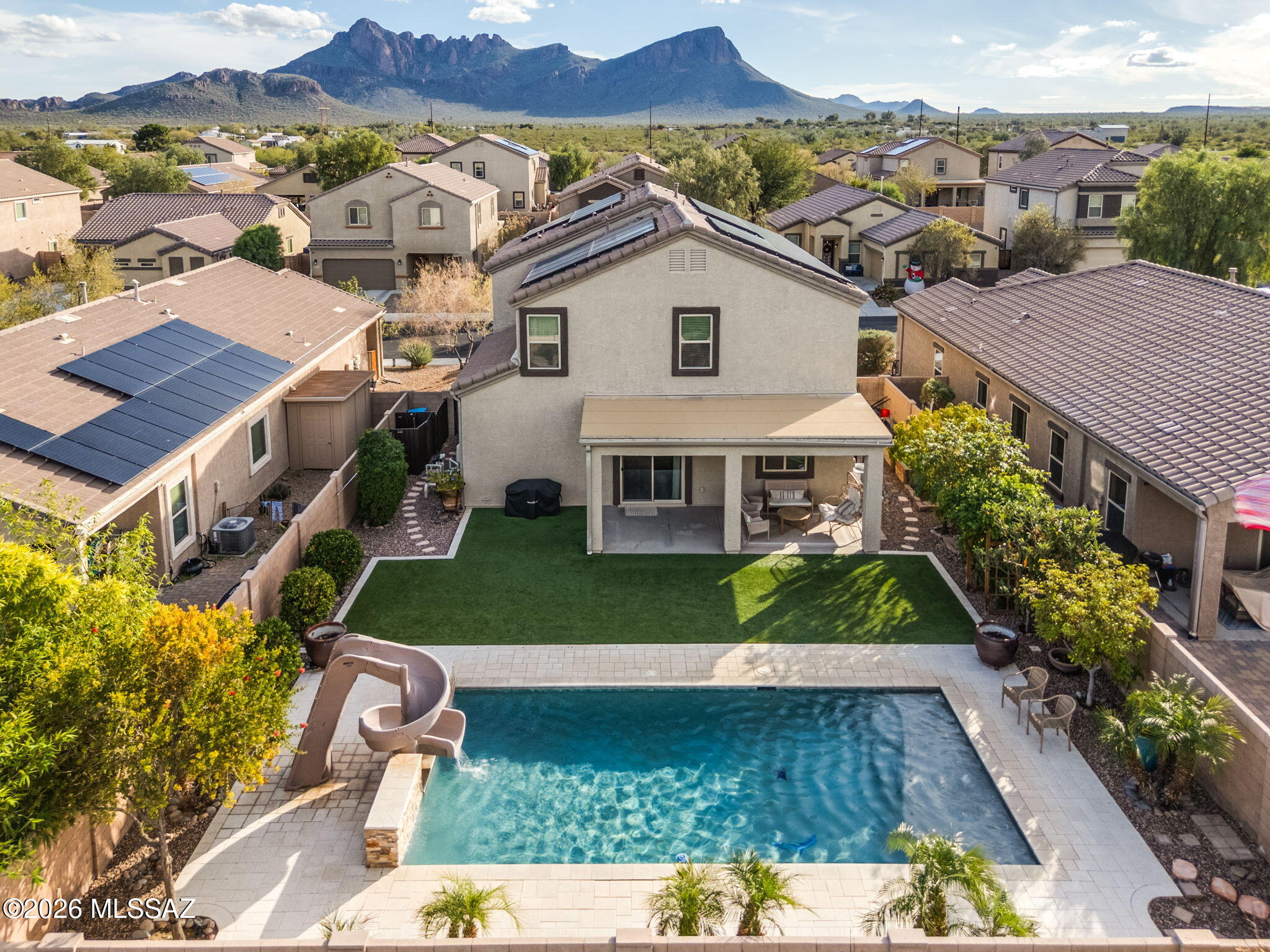 PRICE IMPROVED! Located in the highly desirable Saguaro Bloom community, this beautifully upgraded home offers the perfect blend of comfort, efficiency, and backyard luxury. PAID OFF SOLAR provides ultra savings on monthly energy cost affording the Seller to pay just $393.10 over the trailing 12 months.

Enjoy your own private oasis featuring a sparkling pool with a slide and waterfall feature, outdoor shower, a low-maintenance turf area for additional outdoor living, and lush landscaping that includes a variety of vegetation and greenery -- complete with your own large garden bed. All is supported by automatic irrigation to keep everything thriving year-round. With NO REAR NEIGHBORS, you'll appreciate the added privacy and open feel. SUPER CLEAN, MOVE-IN READY HOME! Inside, the home boasts a spacious open layout highlighted by a large loft area and a dedicated office   ideal for remote work, hobbies, or additional living space. Upgrades are found throughout, including a fully custom half bath, granite countertops and backsplash, a fireplace entertainment center, and a large primary bathroom with a tiled shower.

Energy efficiency shines with paid-for solar, helping reduce utility costs. The finished garage is equally impressive, featuring epoxy floors, built-in cabinets, and overhead racks for maximum storage and functionality.
This move-in ready home combines thoughtful upgrades, versatile living spaces, and resort-style outdoor amenities   all in one of the area's most sought-after communities, truly checking all the boxes.