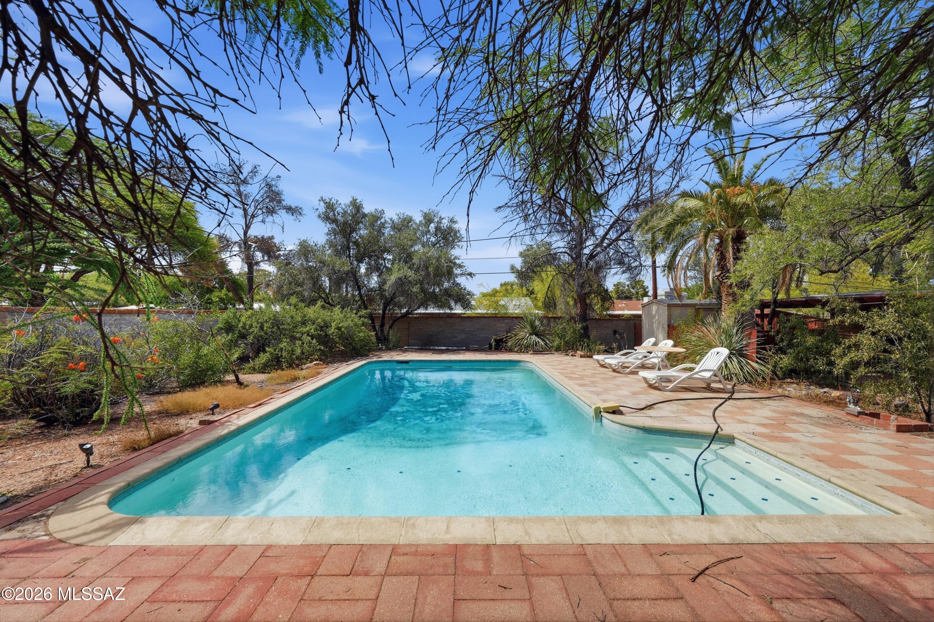 Ideally located in the highly desirable Highland Vista neighborhood, this rare double-lot property offers endless potential. The 3-bedroom, 2-bathroom home spans 1,921 square feet and features a spacious covered porch, sparkling swimming pool, two storage sheds, a carport, mature landscaping, a new roof, and a new water heater. While the home could benefit from some updating, it presents an incredible opportunity to create your dream home in one of Tucson's most sought-after family-friendly communities. Residents of Highland Vista enjoy a large neighborhood park, playground, gated community pool, pickup soccer games, and year-round neighborhood events and gatherings. Centrally located with generous outdoor space and an unbeatable community atmosphere, this property offers the perfect combination of location, lot size, and potential.