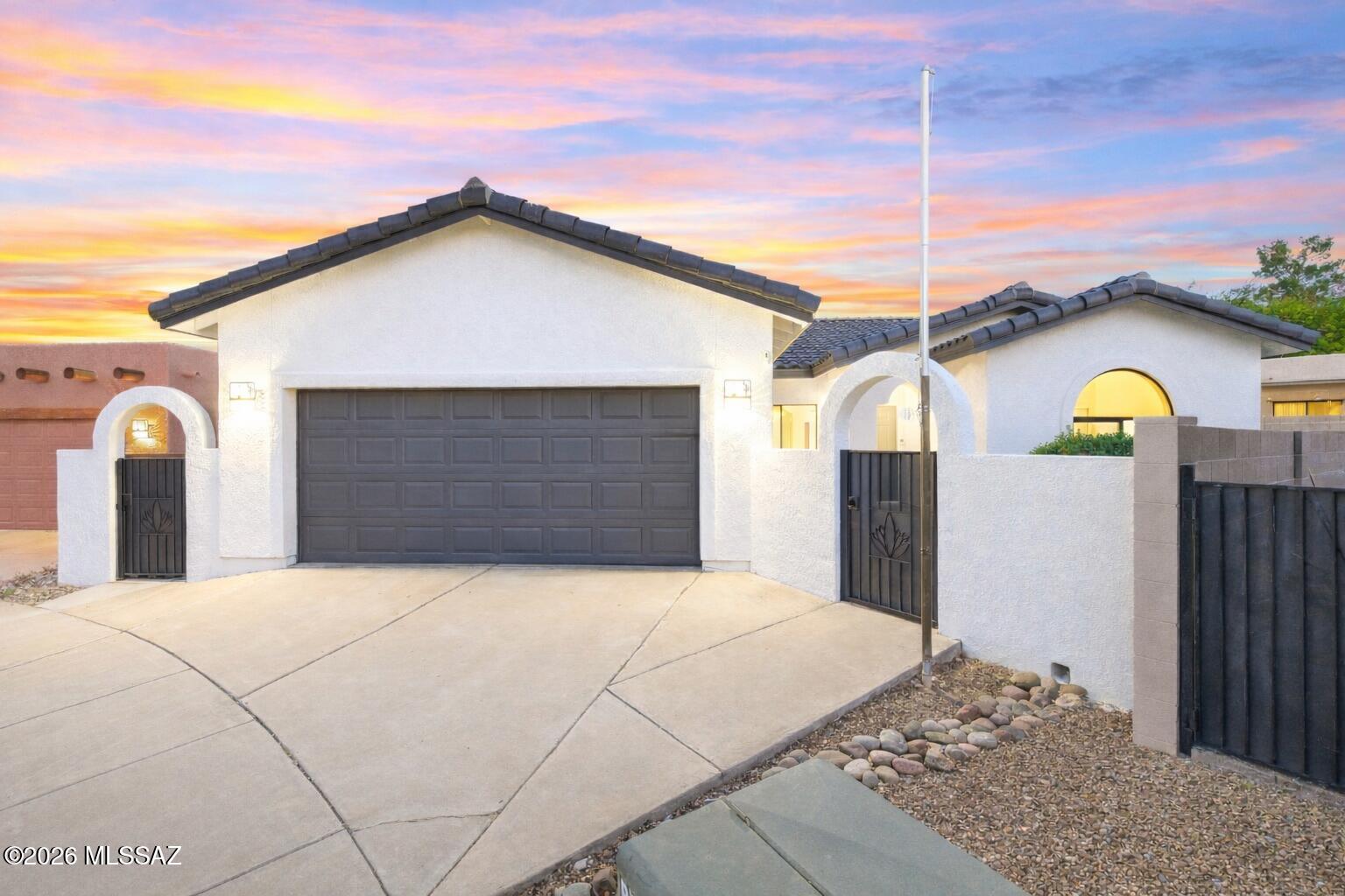 Spectacular Rancho Eireann residence featuring views of the Rincon Mountains and a Sparkling Pool. Enter through the gated archway to your desert sanctuary. This 3-bedroom, 2-bathroom home spans 1,803 square feet and showcases a fantastic open floor plan. The Great Room includes a beautifully updated kitchen with a center island, a spacious family room with a fireplace, and a breakfast nook with bay window. The front dining area overlooks the charming courtyard. The desirable split bedroom layout enhances privacy. The expansive owner's suite offers walk-in shower, soaking tub, dual sink vanity, and walk-in closet. The sprawling Arizona Room & Office look out onto the stunning backyard. Unwind on the covered patio or enjoy the refreshing pool, and don't forget the lovely private side yard.