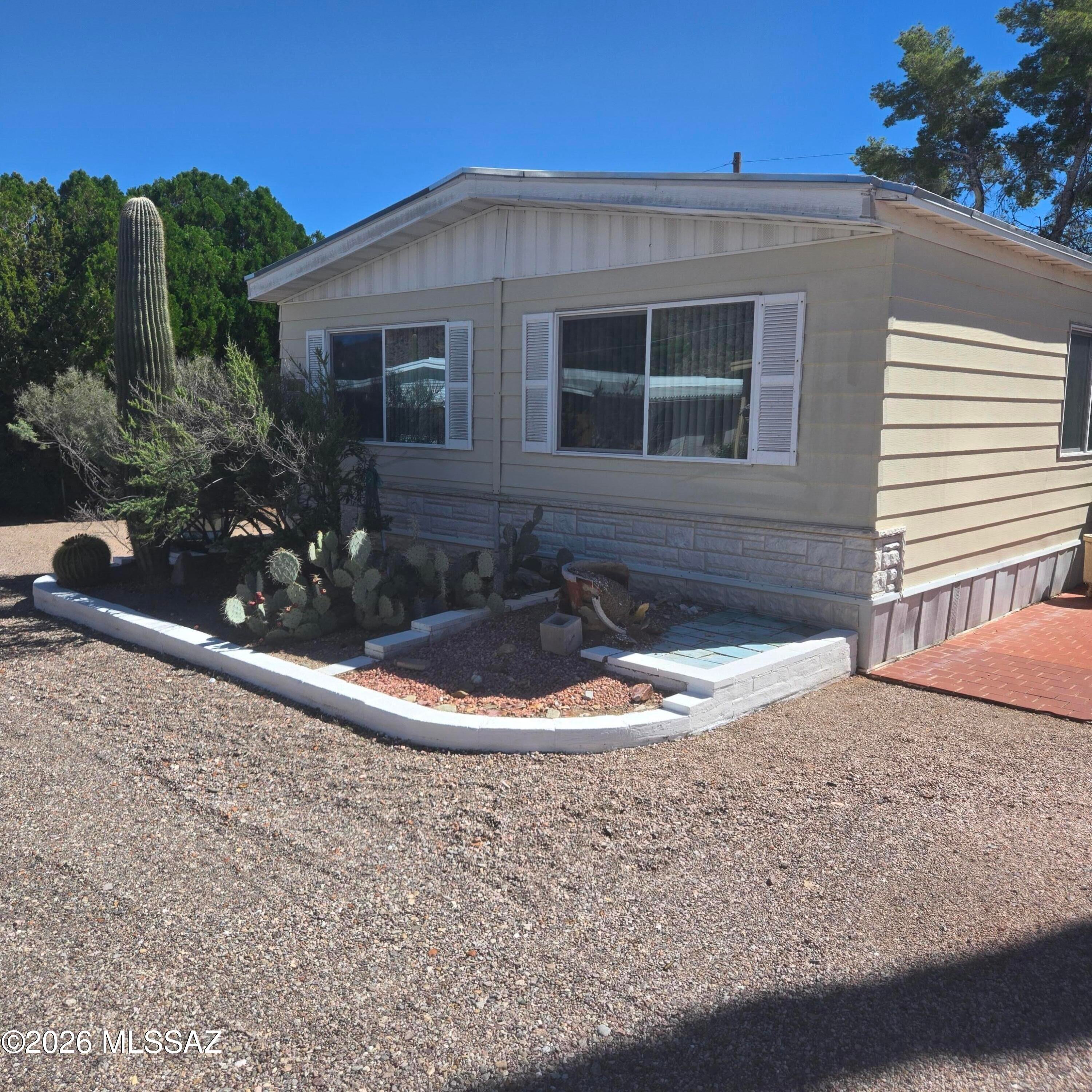 Enjoy easy Arizona living in this 2-bedroom, 2-bath home offering 1,536 sq. ft. of comfortable space. Features include a spacious Arizona room, cozy fireplace, breakfast bar, and desirable north-facing orientation. A large, fenced yard provides plenty of space for outdoor living, pets, or gardening, and you own the land. Located in an active community with two large swimming pools, an 18-hole executive golf course, tennis courts, Circle Park, and a recreation center. Conveniently close to numerous hiking trails and just 20 minutes from downtown Tucson, providing the perfect balance of recreation, relaxation, and accessibility.