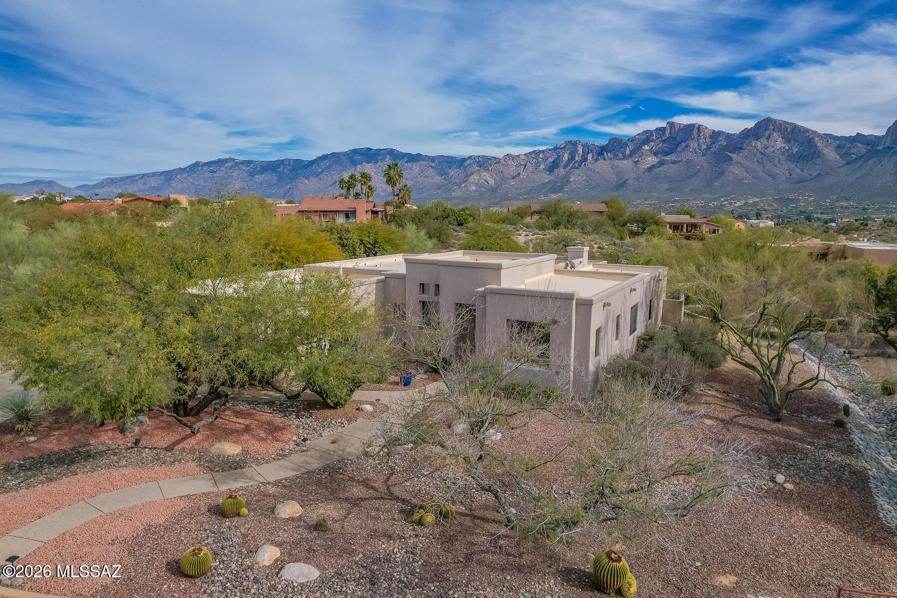 Experience a luxurious and inviting ambiance plus resort style yard at this 3BD/2BA + Den (2,610 sq ft) home in gated Canada Hills Estates. Large .67 acre lot backs to open space for added privacy and unobstructed views of the Catalina Mountains and City Lights. Striking entry boasts architectural detail flanked by an elegant Dining Room with dramatic windows and soaring, recessed ceiling, plus a cozy Den with outer recessed  bookcase. Gorgeous Travertine tiled floors enhance the main living areas along with rich-hued alder cabinetry throughout. Gathering room, at the heart of the home, hosts a corner gas fireplace with Travertine surround, in-wall media cabinet and wired sound, custom valances and spectacular views. Gourmet island kitchen features granite slab countertops, electric cooktop & in-wall ovens, ample cabinetry with roll-out shelves, work desk and dining area with views. Private Owner's suite with picture perfect views accesses rear patio and a luxury bath with dual vessel sinks, glass block walk-in shower & window, plus gorgeous custom walk-in closet. Split guest rooms (one with views) access a central hall bath with dual sink vanity and tiled, glass front tub/shower. Extended laundry room features a granite countertop and sink. Additional amenities include wood shutters in Dining Room/Den, berber carpet in bedrooms/Den, security system, all new water lines, 5 year transferable roof warranty, smart irrigation system with Rachio monitoring, plus extended 3-car garage housing a wall of storage cabinets, overhead storage rack, water softener and furnace with humidity control. Retreat to a tranquil outdoors and enjoy the covered patio with speakers, grill station with rolling sunshade, heated PebbleTec saltwater pool with rock waterfall, Kool Deck and IntelliChem smart pool cleaning system, lush vegetation, mature shade, palm & citrus trees, plus the morning sunrise and evening city lights and sunsets upon the Catalinas. Nearby golf, parks, hiking trails, restaurants, shopping and more!