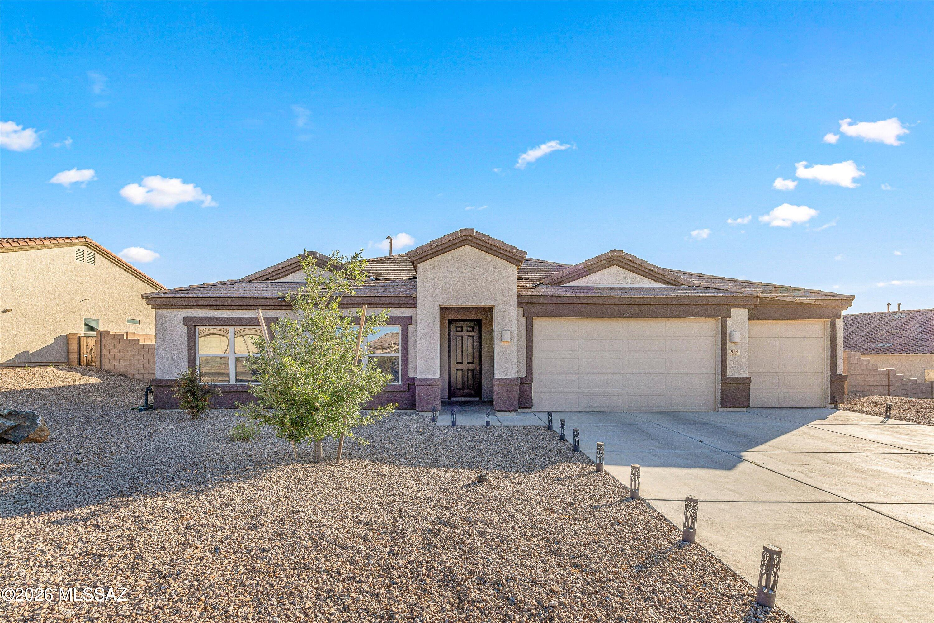 Discover this exquisite single-story home featuring four bedrooms and three full bathrooms, complemented by a dining room and a den, all set against the picturesque backdrop of the Santa Rita Mountains. The residence boasts a split floor plan and an open-concept living area, ideal for contemporary lifestyles. Upon entering the kitchen, you will find a spacious quartz island, stainless steel appliances, and sleek dark cabinetry that enhance the modern aesthetic. 
Additionally, the property includes a tandem three-car garage with epoxy flooring and a generously sized backyard, ready for personalization by its new owner. With its stylish design and thoughtful layout, this home seamlessly blends comfort and elegance.