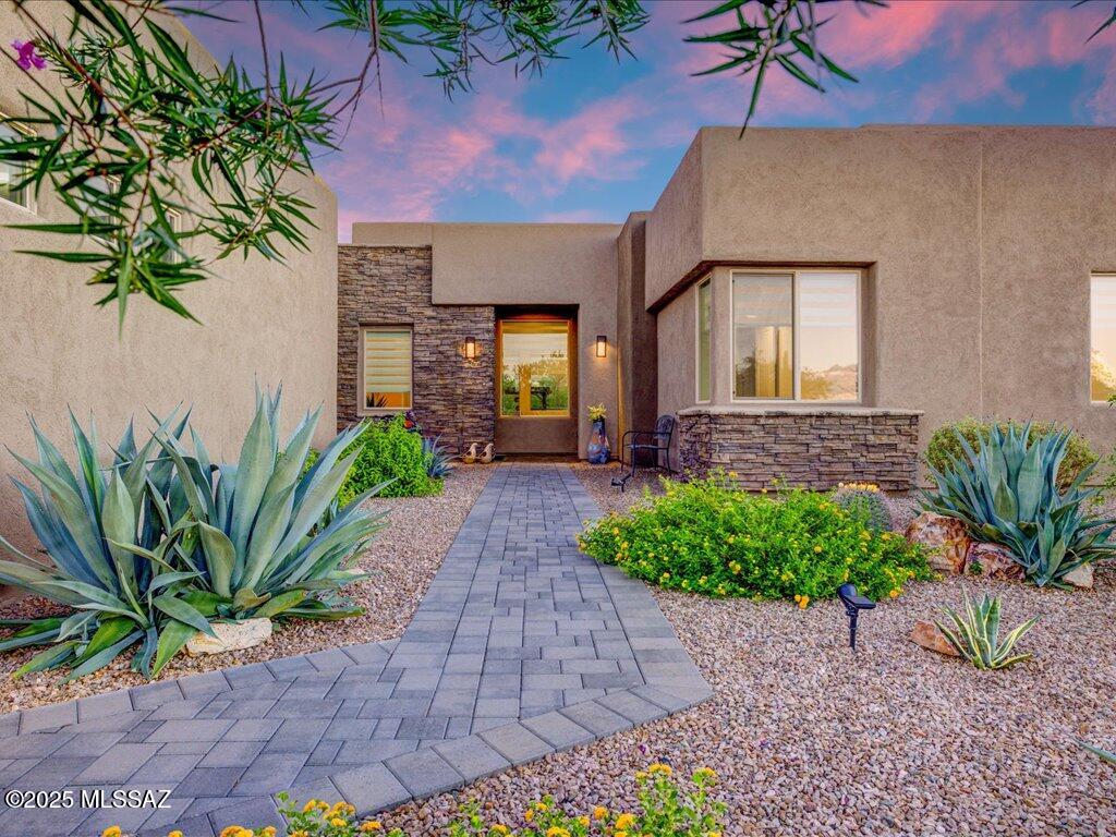 Welcome to refined desert living in the desirable gated community of Stone House! Situated on a generous 0.56-acre lot, this beautifully maintained 2,757 sq. ft. home offers 3 bedrooms, a dedicated office, 3.5 bathrooms, and a spacious 3-car garage. From the welcoming foyer and picture-window entry to the open-concept floor plan, every detail blends comfort, style, and functionality. The impressive family room features soaring 13-foot ceilings and a gas fireplace, creating an inviting space to relax or entertain. At the heart of the home, the gourmet kitchen showcases granite countertops, abundant cabinetry, a kitchen island, and a skylight that fills the space with natural light. The thoughtfully designed bedroom layout offers privacy and convenience, with ensuite bathrooms for each bedroom. The spacious primary suite features direct access to the expansive covered patio, creating a seamless connection to outdoor living. Step outside to enjoy low-maintenance desert landscaping, a paver driveway and walkway, and plenty of room to take in the peaceful surroundings. Located in Stone House, residents enjoy a gated setting, spacious homesites, and scenic walking areas, all with convenient access to golf, shopping, dining, Madera Canyon, and the historic charm of Tubac. Experience the perfect blend of space, comfort, and desert elegance in this exceptional Sahuarita home!