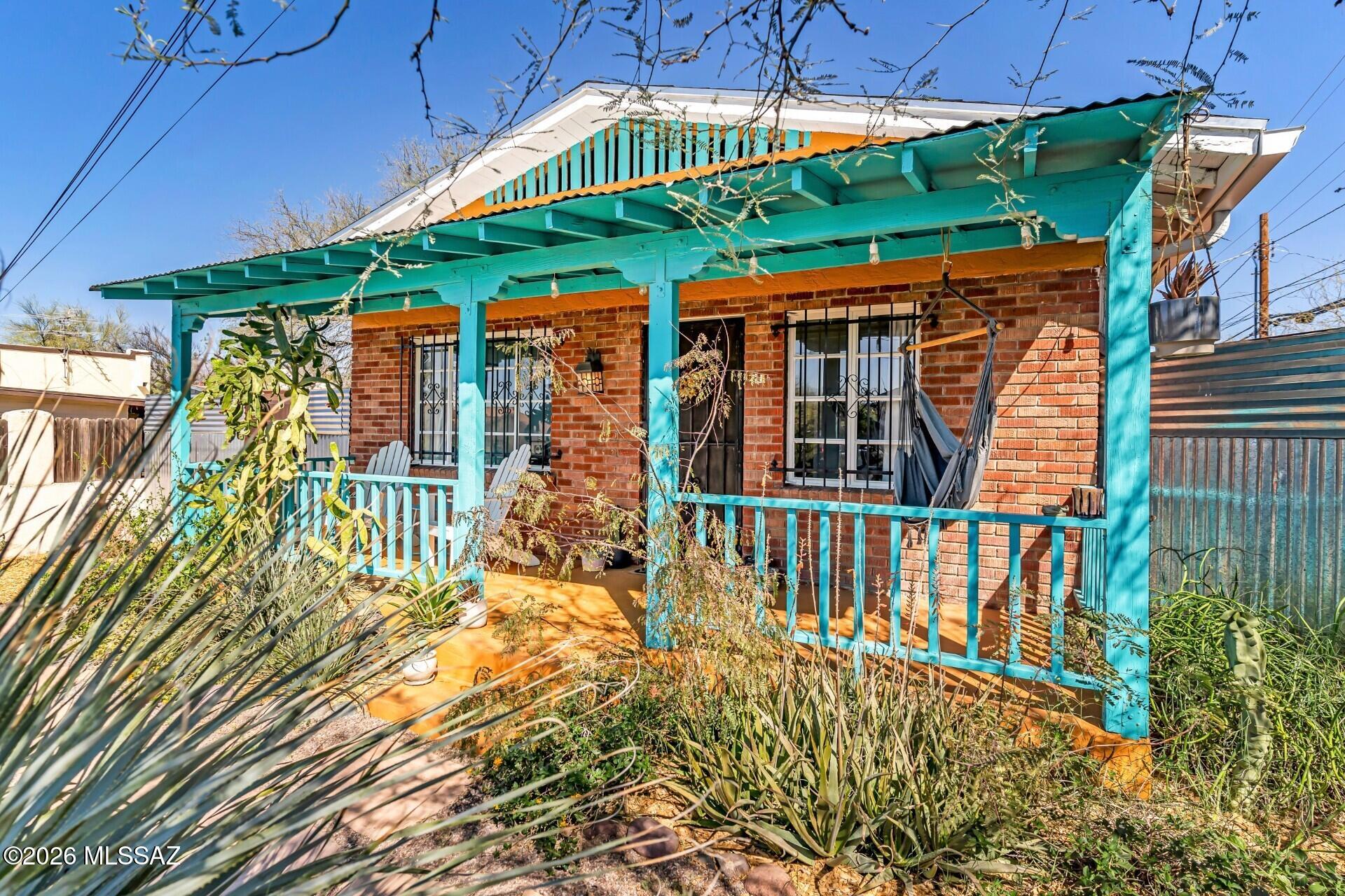 This 1928 brick bungalow in the Historic Feldman's Neighborhood blends original character with thoughtful updates and a distinctly creative feel. From the moment you arrive, the home reflects a sense of care, individuality, and connection to its surroundings.
The mature native vegetation, artisan metalwork, and enchanting front porch create a perfect introduction to this sweet abode.
Inside, hardwood floors and natural light create a warm, inviting atmosphere. The spacious kitchen pairs concrete countertops with stainless steel appliances, offering a functional workspace that complements the home's vintage roots. A foyer with storage and flexible office/den provides options for a guest room, nursery, or creative studio.
The outdoor spaces are a true extension of the home - designed with intention and rooted in Tucson's desert aesthetic. Corrugated metal accents, native specimen plantings, and a potting shed create a setting that is both practical and expressive, ideal for gardening, gathering, or quiet retreat.
Every space--inside and out--has been used with purpose, emphasizing efficiency, quality, and thoughtful design. This is a home that feels both grounded in its history and adaptable to modern living, all in one of Tucson's most established central neighborhoods.