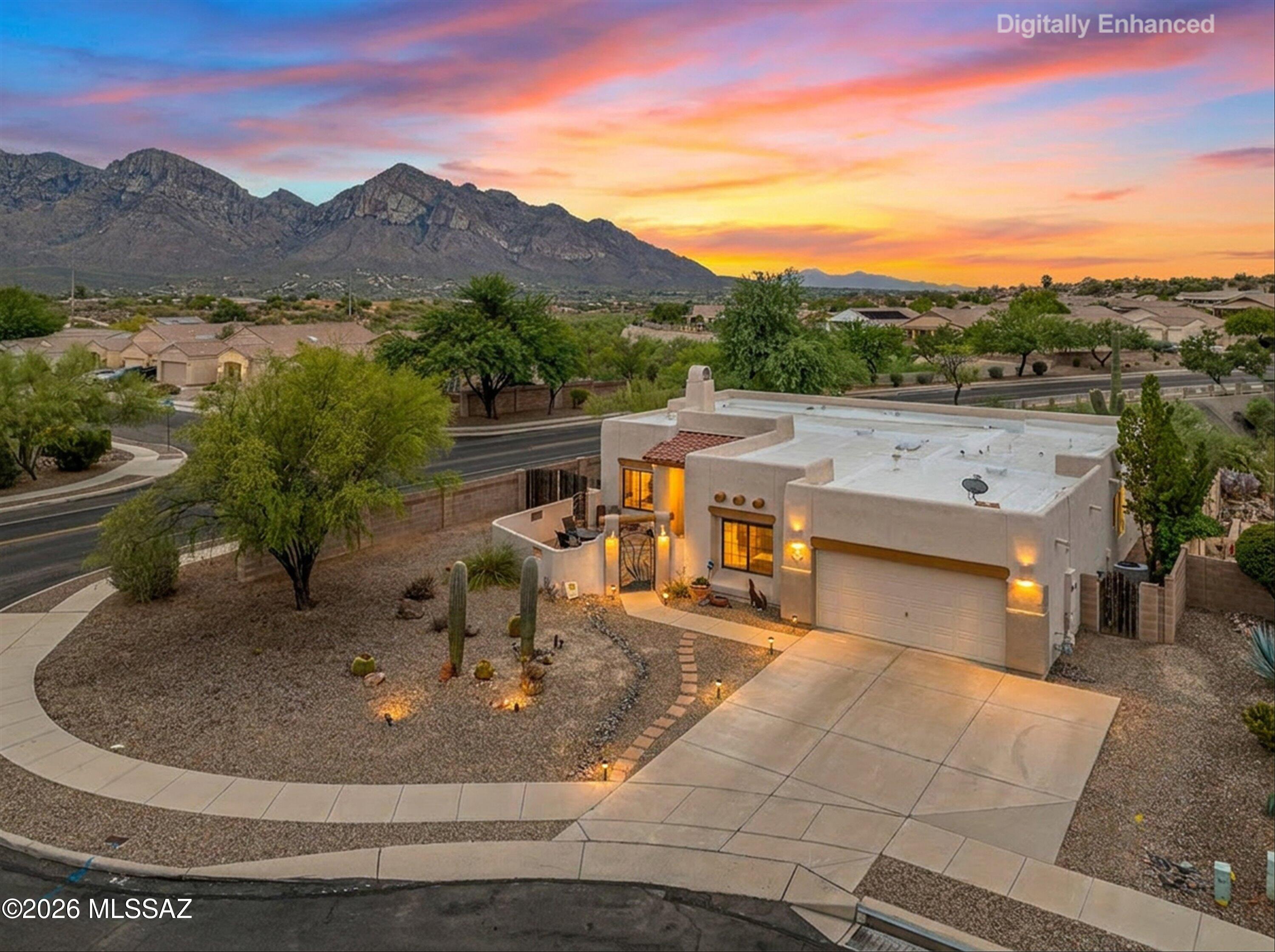 Welcome to this stunning Southwestern-style home perfectly positioned on a prime corner cul-de-sac lot with no back neighbors! This home offers the privacy, views, and serenity that desert living is all about. From the moment you arrive the mature saguaro cactus and glowing landscape lighting set the tone for something truly special, especially at sunset, when the Catalina Mountains turn golden right before your eyes.

Inside, this thoughtfully updated 3-bedroom, with a den, 2-bathroom home offers a warm and inviting layout designed for both everyday living and effortless entertaining. The open-concept family room features high ceilings, wood plank tile, and a cozy tile-surround fireplace.

The heart of the home is a beautifully updated kitchen. Granite countertops, painted cabinetry, a dark slate tile backsplash, and stainless steel appliances create a sophisticated yet functional workspace. A stunning copper farmhouse sink anchors the window overlooking the beautiful backyard, while the oversized two-tone island provides generous prep space, additional storage, and a natural gathering spot for family and friends.

The primary suite is a true retreat, featuring direct access to the back patio, views of the backyard, and a spa-inspired ensuite bath complete with a walk-in shower accented by river rock tile, a soaking tub, and a walk-in closet with built-in shelving.

Stepping into the backyard you'll discover your own private desert oasis. With no back neighbors, the backyard feels expansive and peaceful -- a paver patio, mature saguaro, lush garden, and a fire pit seating area all frame breathtaking mountain and sunset views that never get old.

This is more than a home -- it's a lifestyle. Don't miss your opportunity to own this one-of-a-kind property in one of Tucson's most desirable settings.