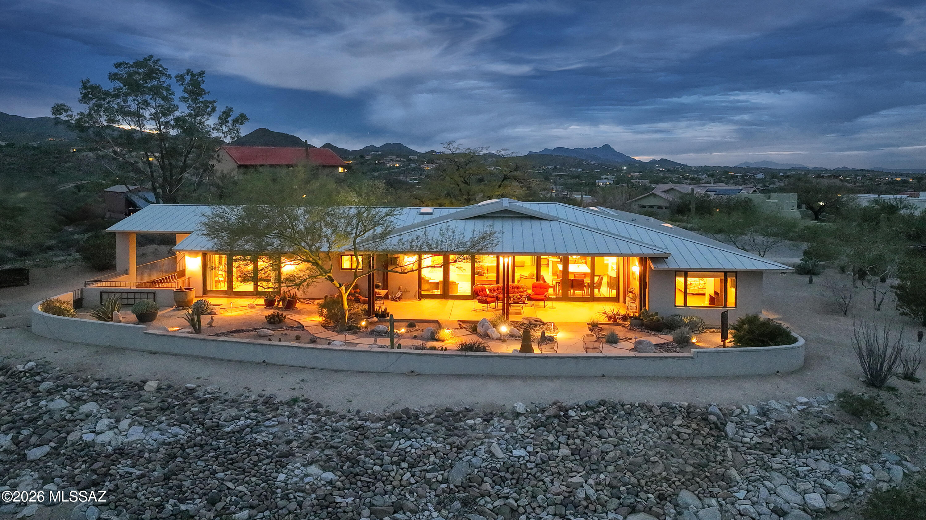Spectacular, completely re-imagined home overlooking the natural beauty of Sweetwater Preserve. Complete architectural remodel in 2010. Floorplan was revised, roof was raised and replaced with stunning metal. Beautiful stucco finish with professional landscaping including flagstone patio & walkways with rusted metal garage doors. Rich colored concrete floors throughout. Custom chefs kitchen with granite and under-mount microwave. Open plan is perfect for entertaining with a flow to the awe inspiring covered patio and unobstructed views. The den makes a perfect TV room, the primary suite features a view wall of glass french doors, double walk-in closets, bidet & multi head shower. Bedroom 2 is connected to the hall bath, Bedroom 3 has its own sitting room. Huge laundry/ pantry. RV carport