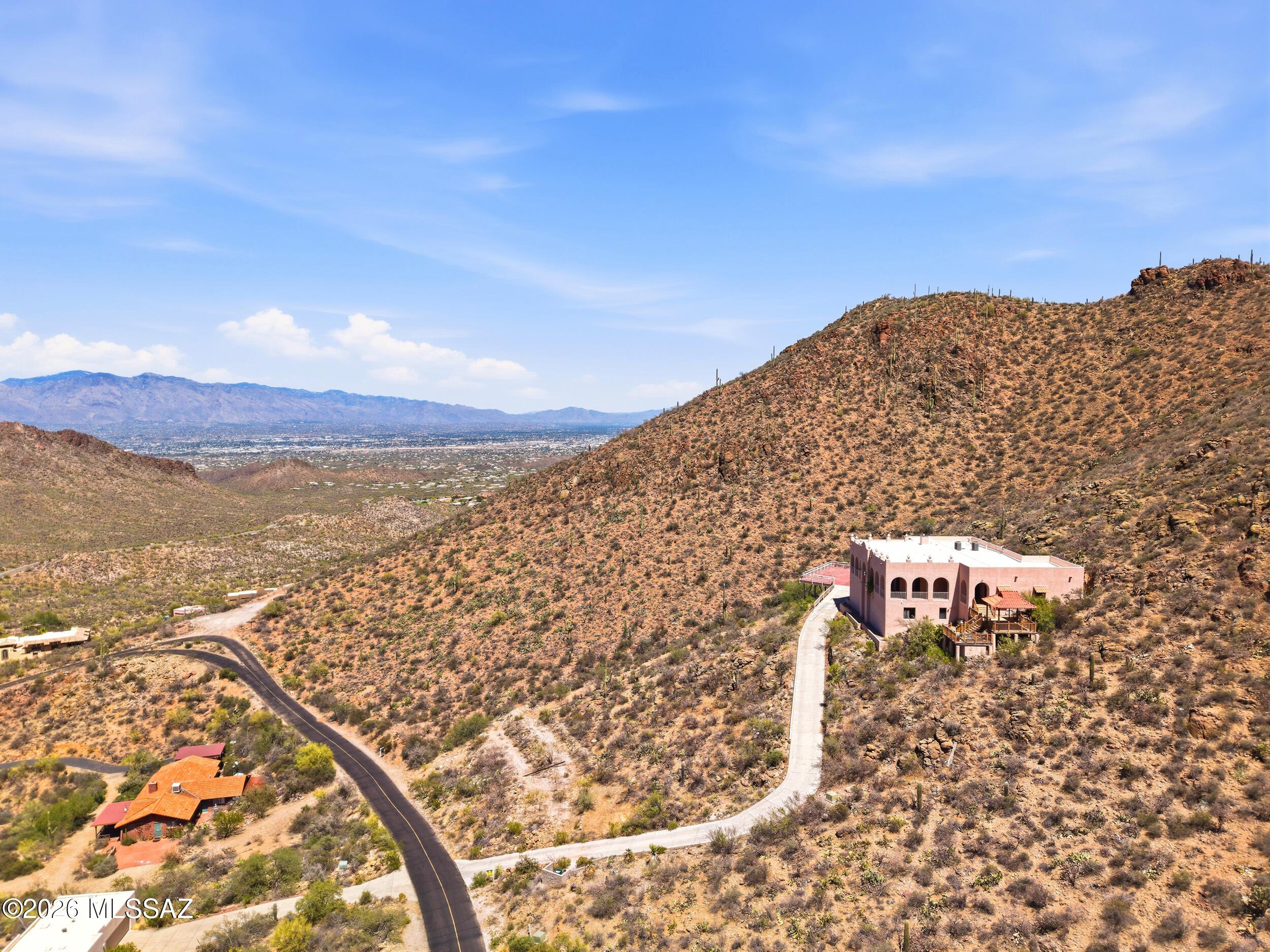 Hilltop home on one of the highest lots in the area with panoramic mountain, city, and desert views. Built by a contractor with high-end construction and finishes throughout. The main level includes a gourmet kitchen, dining area, primary suite, and two additional bedrooms. Lower-level features guest quarters with a kitchen and two large flex rooms suitable for bedrooms, offices, or recreation space. Ideal setup for multi-generational living, guests, students, or live-in staff. Private setting with a functional layout and extensive living space.