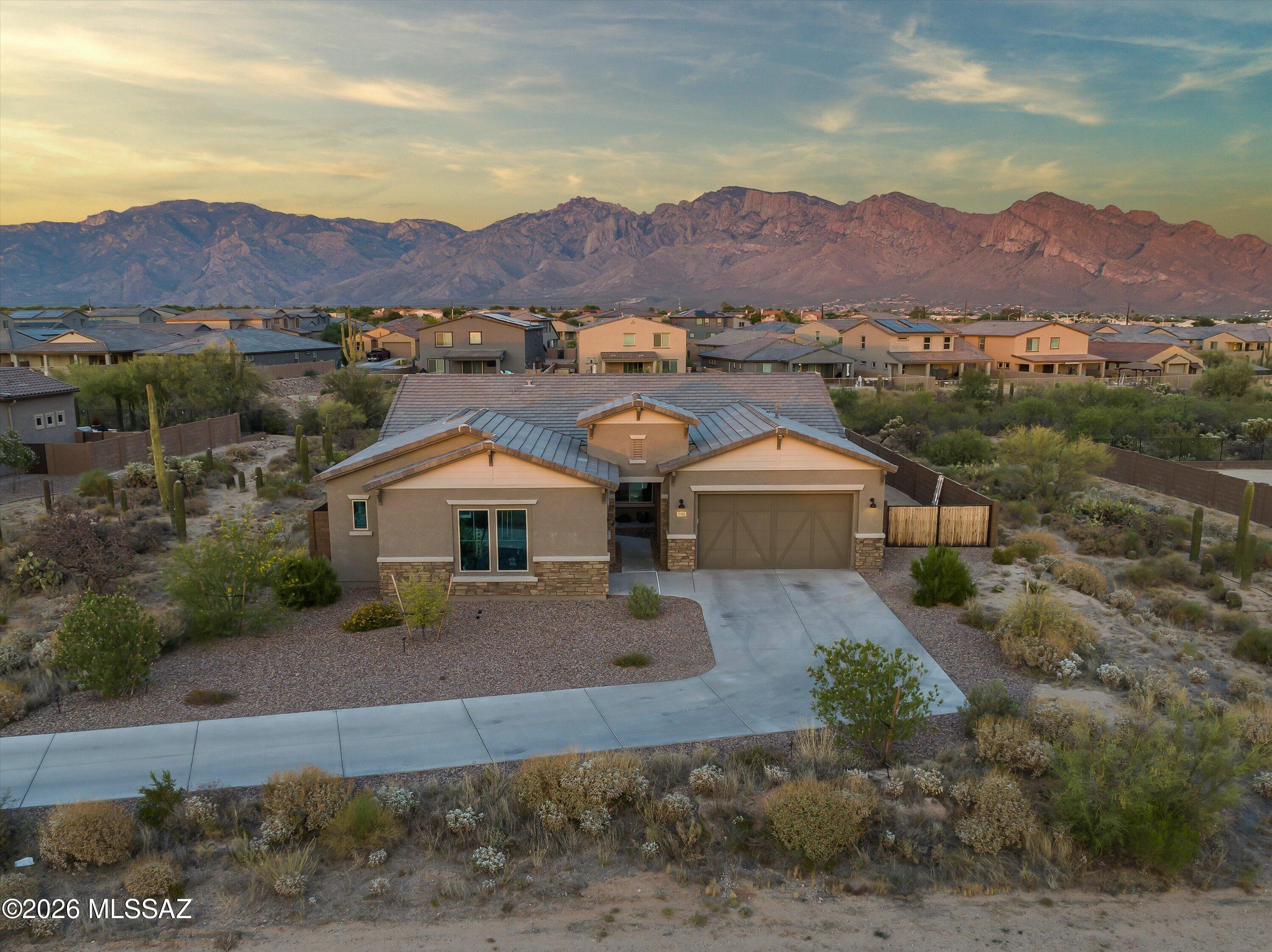 Better than new construction! Exquisite gated community in Oro Valley! Home boasts 4 BR, 3.5 Baths, 3-Car Garage, Office + Flex Room.  Custom hard wood throughout the living areas with carpet in bedrooms, additional insulation in walls for sound proofing, 12' RV side gate, view fencing & more! 4th bedroom has an ensuite bathroom. Kitchen: QUARTZ counters w/oversized island, white staggered cabinetry, gas cook top, double ovens & an amazing walk-in pantry. HUGE Laundry room with sink + numerous custom cabinets. Primary bath: custom shower w/ walls of tile, two vanities, soaking tub + a closet built for royalty. Glorious Views of the Catalinas from your large covered patio. Entertainer's Paradise. Close to schools, shopping, and dining!