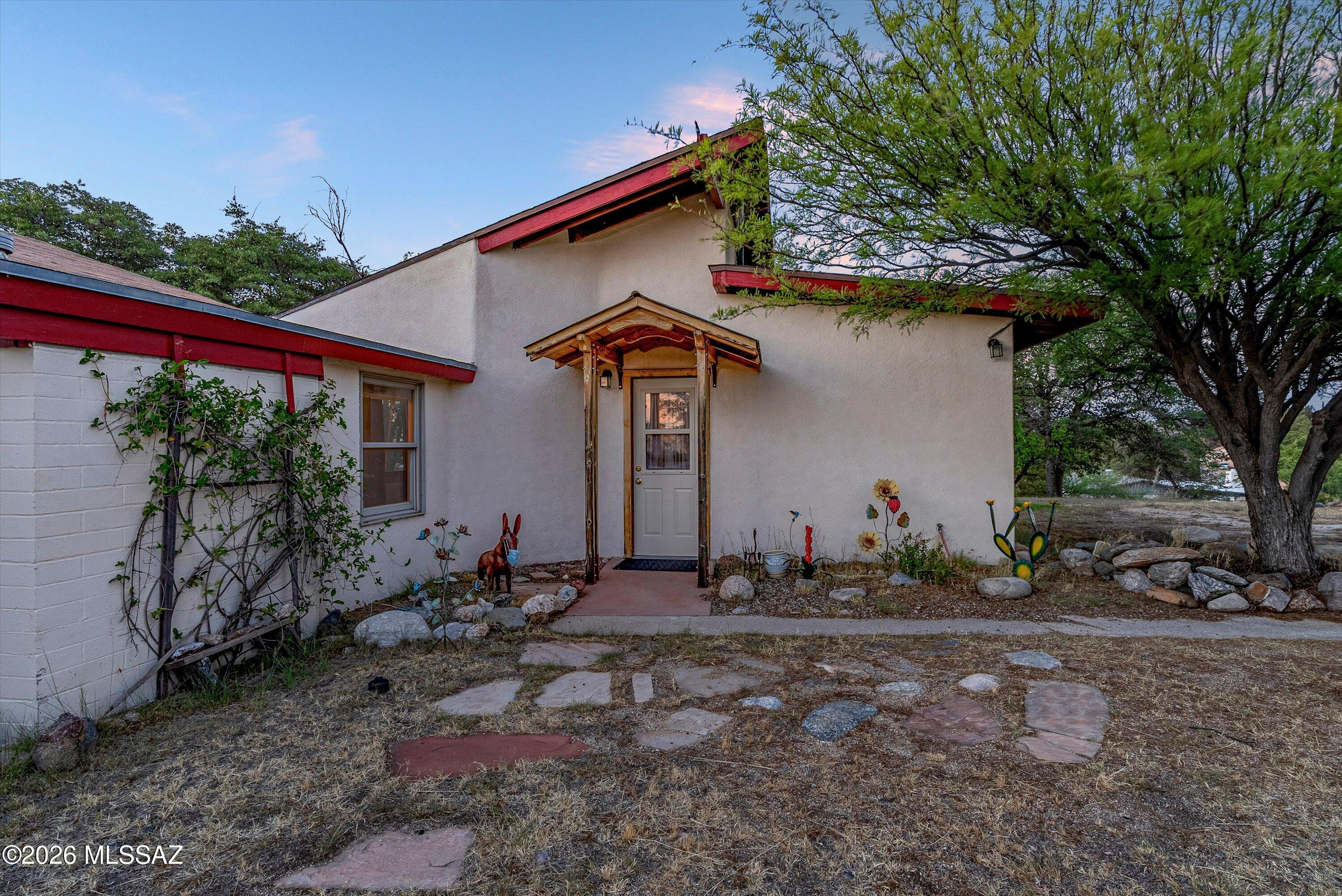 Charming 2-bedroom, 2-bath home on nearly an acre with expansive Arizona mountain and sunset views.The natural, mostly low-water landscaping features several mature desert-adapted trees (including oak, pine, cedar, plus an apricot tree) offering beauty and peace with relatively minimal upkeep. Inside,the home features a bright living room with vaulted ceilings and a distinctive lodgepole column, along with a cozy den anchored by a wood-burning brick fireplace [-perfect for cool desert evenings].Enjoy outdoor living year-round with a screened-in patio, open patio, and a handcrafted covered portico created by a local wood artist.A custom wood T-pole adds character and is ideal for bird feeders or wind chimes.A standout feature is the detached 24'x 36' block garage-see under more description. with a metal roof, attic storage running the length of the building, and a dedicated workshop or artist studio built within the structure. The workshop is separated from the parking area by an interior wall and door, offering privacy while maintaining convenient access from the garage, and it has a 12-foot roll-up door for excellent airflow and natural light into the workshop space, plus electricity and pre-run water lines for future expansion.
An intentionally-rustic shed (with concrete foundation and metal roof provides additional storage for tools and equipment. Originally platted as two lots, the property offers space for a second home, guest quarters, or potential conversion to a studio or casita-ideal for multi-generational living, rental income, or creative use.  Additional parcel is included (parcel #308-25-082B).  Taxes are on both parcels.