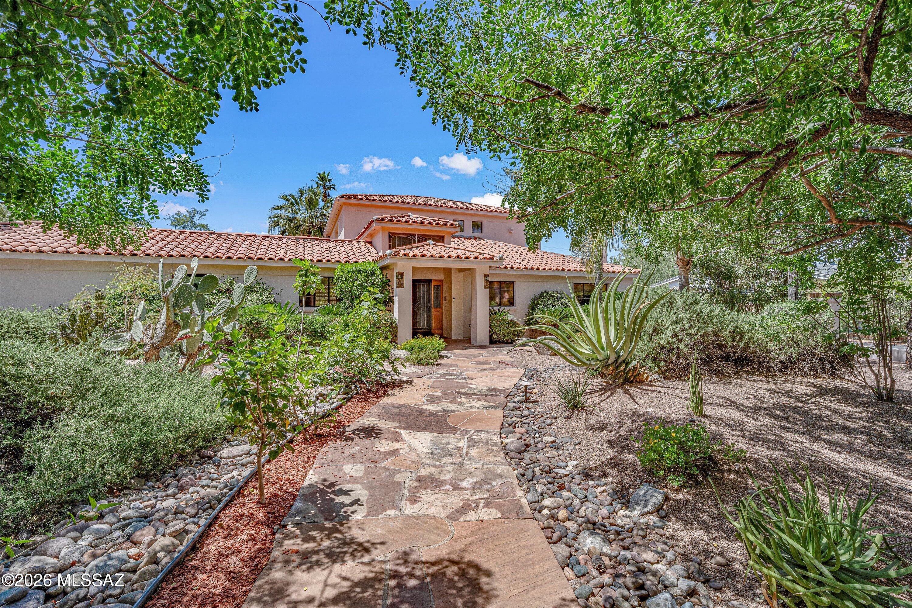 Situated in the coveted historic neighborhood of El Encanto Estates, this must-see luxury residence offers the perfect balance of privacy and modern living in the heart of Tucson. A renovated kitchen features modern appliances and beautiful custom finishes. The spacious family room is highlighted by a seamless indoor/outdoor bar area. The oversized primary suite serves as a true retreat complete with a private balcony. Step outside to your own private oasis in a serene setting with mature landscaping, large ramada with fireplace, and resort-style saltwater pool and spa. This property has a water well, and is listed on the National Historic Registry, providing valuable tax advantages. The premier central location is just moments away from the best amenities that the city has to offer!