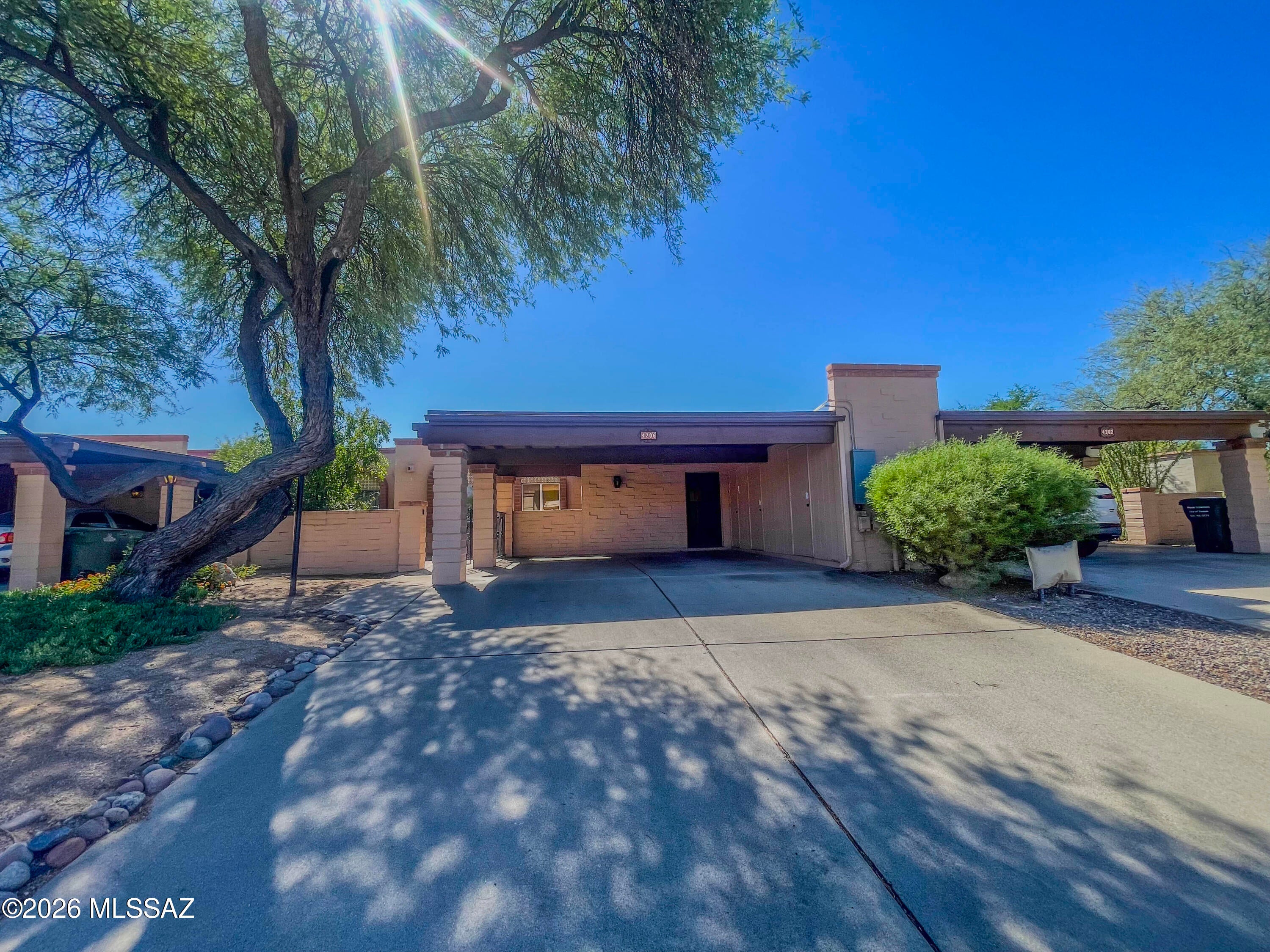 Classic Central Tucson townhome near the U of A! This well-built adobe brick 3 bed/2 bath home sits in a quiet community with a sparkling pool, spa, clubhouse, & rec center. The HOA covers water, sewer, trash, & exterior paint. A lovely entry courtyard welcomes you into a spacious great room with a cozy brick fireplace, ceramic tile floors, & a dining area. The kitchen offers black & stainless appliances & ample cabinetry. The professionally built Arizona room adds 185 sf, for approx. 1,633 sf total under roof, & opens to the back patio & enclosed rear yard, where trees & a common area behind provide added privacy. Enjoy the convenience of an indoor laundry with washer/dryer, plus an attached 2-car carport with three storage rooms. Close to The Loop, grocery, dining, shopping, & medical.