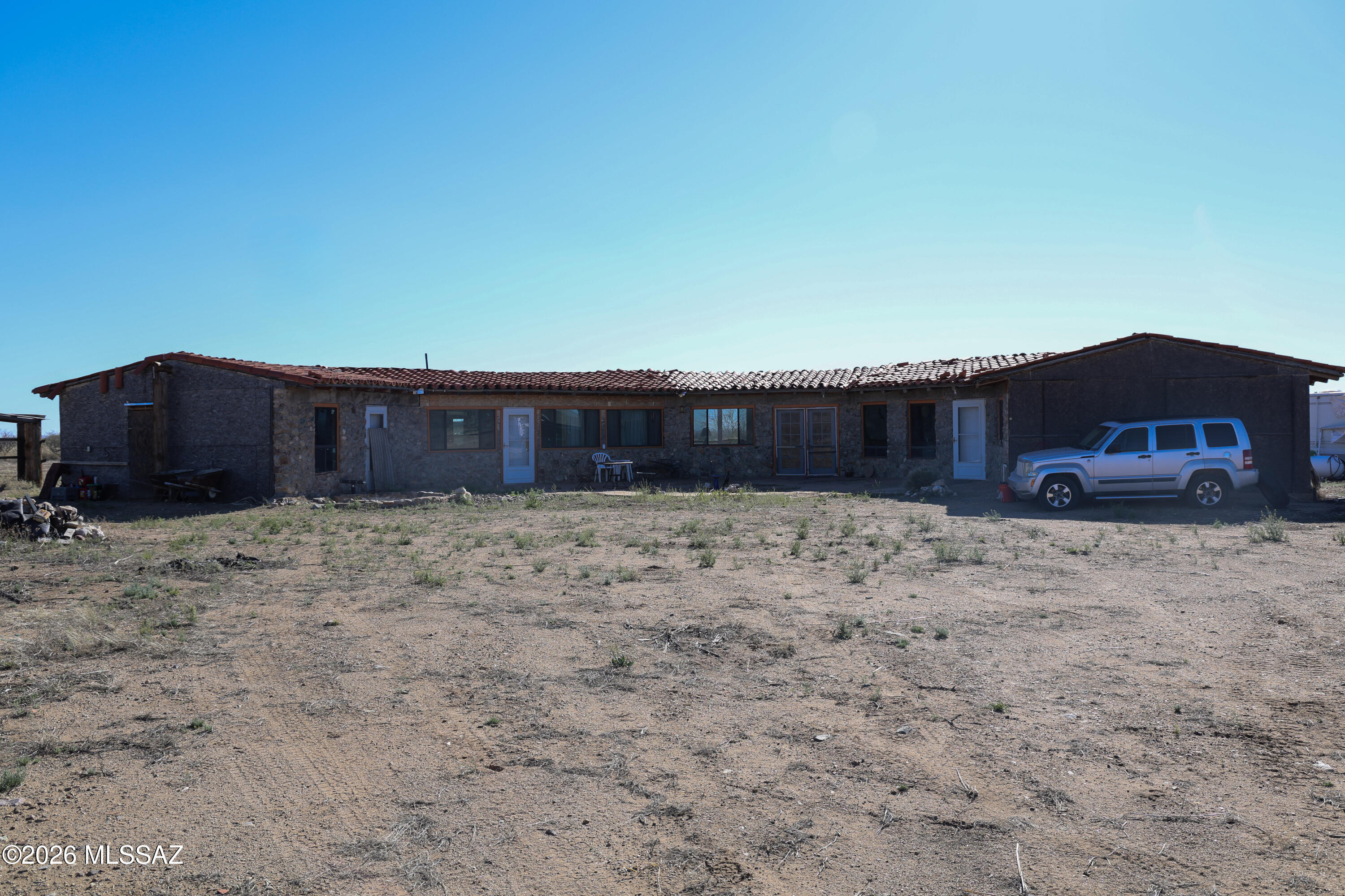 Highly Sought after RU-4 zoning, 40 acres high desert, distinctive owner-built home -offers privacy, character, and the opportunity for self-sufficient living. Designed for off-grid living, the property includes solar panels with 6 batteries, a backup generator, a private well with 1500 gallon storage tank, pressure pump inside & pole barn. Approx. 2,800 sq ft home has a unique half-octagon design that brings in natural light through 24 large windows.
Interior showcases vaulted tongue-and-groove wood ceilings, exposed beams, natural stone accents, and terracotta tile flooring, creating a warm southwestern feel. The spacious kitchen includes wood cabinetry, tile countertops, bar seating and a large center island, dishwasher, electric stove and cooktop. A library-style hallway with built-in shelving adds character and function. The home includes 3 bedrooms (2 rooms/ 1 Studio sleeping area) and 2 bathrooms, with one bedroom currently used as a workshop.  Construction to 2nd bathroom and outside of home will need to be completed by the new owner.

Everything in the Home and On the Property will Stay and CONVEY to the new owners.  There is and RV and Trailer that we will provide the Titles to at Close of escrow.  NOTHING is being Removed. CASH ONLY, not owner Financing.   Septic System was built and design was filed and approve by Cochise County, but owner did NOT follow through with permitting and design was not followed. - Buyer to have a Septic company give quote for corrected design during inspection period.  Seller will NOT correct the issues and Buyer will have to sign HOLD HARMLESS documentation taking on responsibility AFTER closing.