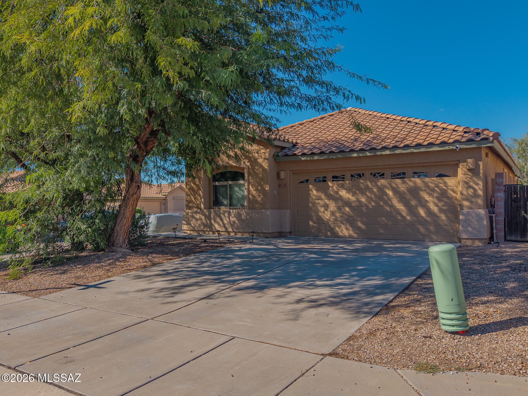 Welcome to a bright and inviting home in Tucson's Sycamore Park community, where soaring ceilings and an open great-room design create an immediate sense of space. The kitchen flows seamlessly into the living and dining areas, making the home ideal for entertaining or relaxed everyday living. Generous windows fill the interior with natural light, while warm cabinetry and easy-care flooring add comfort throughout. Step outside to a covered patio and private backyard with plenty of room to create your own desert retreat. Mature shade trees, mountain views and nearby parks and walking paths complete the setting.