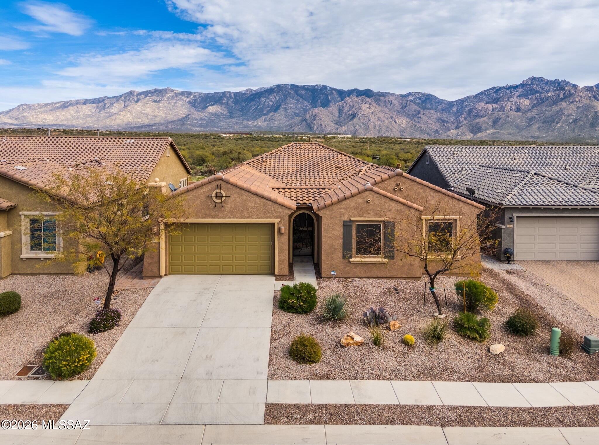 Welcome to this beautiful, almost new 3BD/2.5BA +Den home offering 2,526 sq ft of thoughtfully designed living space. Nestled in the desirable heart of Oro Valley, this home backs to wide open space with no one directly behind and offers a screened-in patio and panoramic Catalina Mountain views. The elegant interior features an open concept floor plan that blends comfort and functionality. Step into the Great room with walls of windows and linear gas fireplace, perfect for gatherings or relaxing at home. Expansive chef's kitchen is a true delight boasting a curved island bar, abundant cabinetry & counter space, center island, plus plenty of room to cook or entertain. Private Owner's suite with spectacular views hosts a sleek bath featuring dual sink vanity, walk-in rain head shower plus plenty of room to cook or entertain. Private Owner's suite with spectacular views hosts a sleek bath featuring dual sink vanity, walk-in rain head shower plus spacious walk-in closet. Split bedroom plan ensures guests enjoy their own quiet retreat. Large central den with double doors provides the ideal space for remote work, game room or reading nook. This modern home also features an epoxy coated garage with water softener, utility sink & tankless water heater, plus retractable window shades, plank tile or carpet, outer solar screens, wired for alarm and security systems, plus front security gate and entrance door. Enjoy your morning coffee or evening beverage on the rear screened, epoxy coated patio. There is an extra elevated patio affording spectacular desert and mountain views. Conveniently located near top rated schools, shopping, dining and walking/biking