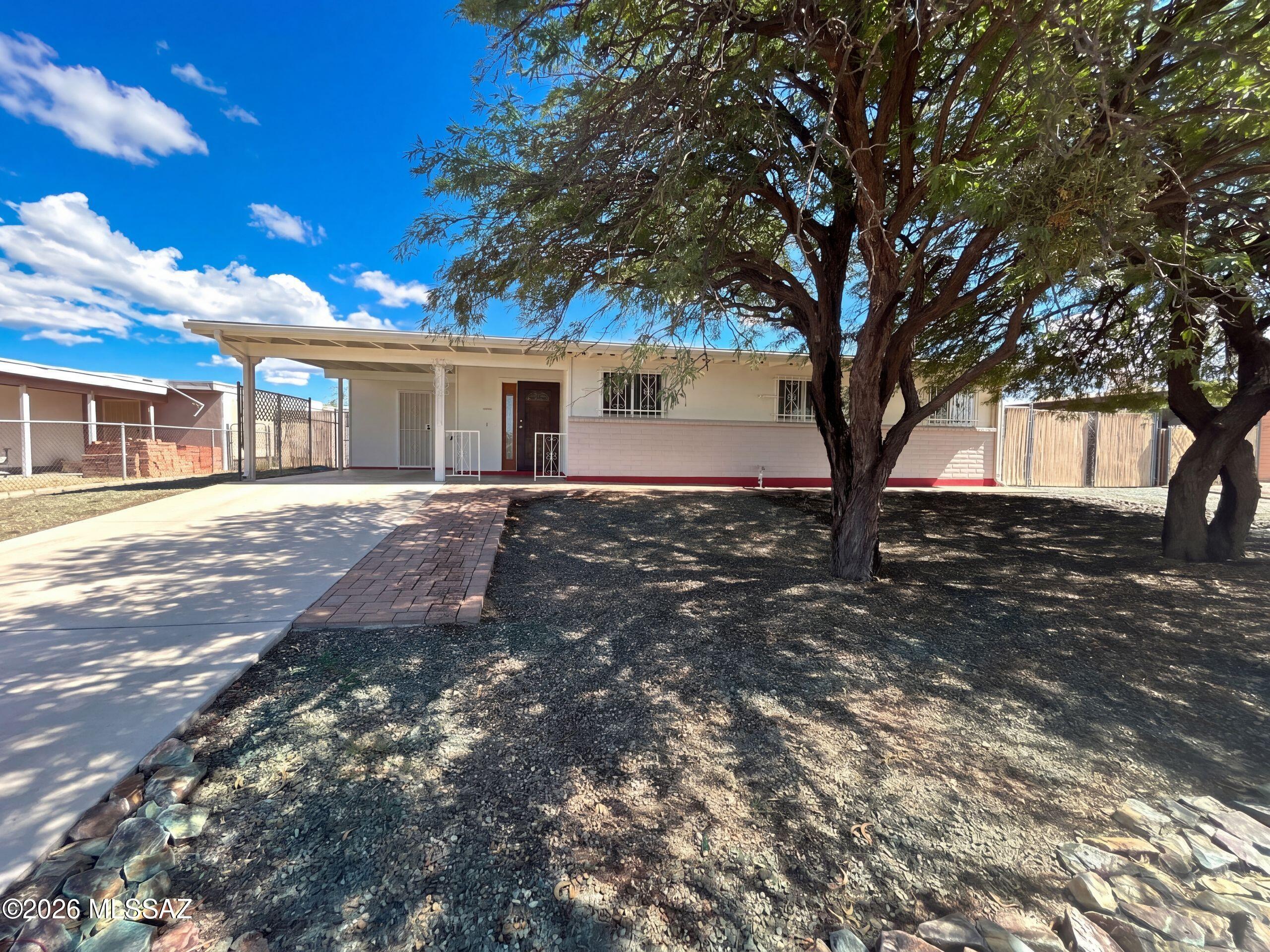 INCREDIBLE BUYER INCENTIVES: $4,000 MORTGAGE CONCESSION. Seller will pay up to $4,000 at closing towards your interest rate buydown if you finance with lender of sellers choice.

A rear porch extends the main living space at 3431 S Champlain Ave, creating a bright connection to a broad backyard with mature trees. Sliding glass doors link the tiled living and dining area to the porch, while the galley kitchen provides white cabinetry, light countertops and a gas range. The primary bedroom combines carpet with a painted masonry accent wall and an adjoining bathroom with a tiled shower. Additional bedrooms sit along the central hall, with a second bathroom featuring a tub and shower combination. Covered parking and a long concrete driveway add everyday practicality to this single-story home