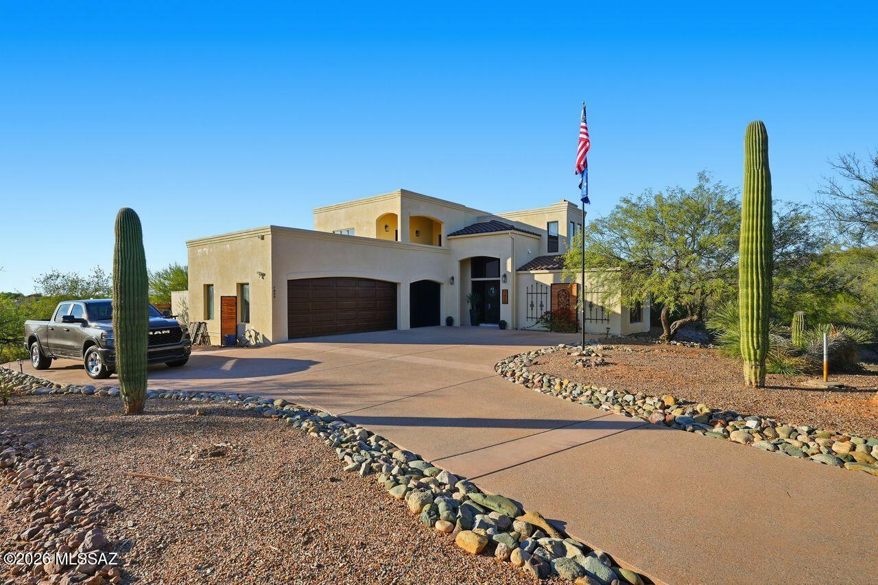 Nestled at the base of the Rincon Mountains is this stunning home, offering a spacious, flexible floorplan, ample outdoor entertaining options, and panoramic views.  The long driveway brings you to a large parking pad and three-car garage.  The stately glass entryway to the home frames the lovely foyer and great room beyond.  Two of the guest rooms are on the first level, along with both a full and half bathroom.  Either of the guest rooms can be used for a den/office.  The downstairs patios have access to the great room and one of the bedrooms.  The infinity pool is just beyond the patio.  Upstairs is the primary bedroom along with another spacious guest room.  Both upstairs bedrooms open to patio balconies that offer unparalleled views of the mountains and surrounding Rincon Valley.