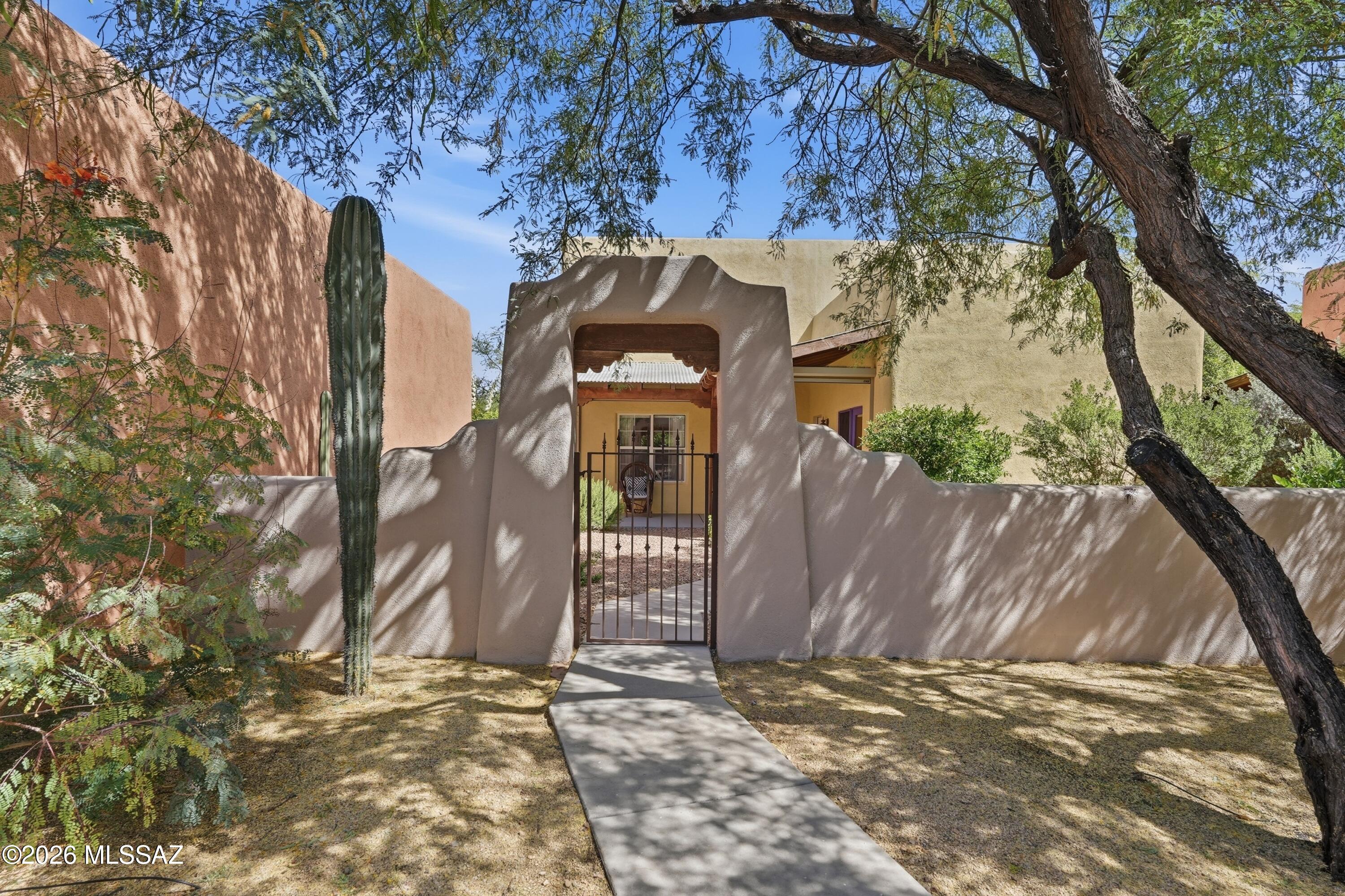Check out this beautiful TJ Bednar home in the heart of Civano, where authentic charm meets thoughtful modern upgrades. Saltillo tile floors and exposed wood beam ceilings anchor the Great Room in timeless Tucson character, while a remote-controlled gas beehive fireplace casts a warm, inviting glow on cool desert evenings. The kitchen and bathrooms have classic tile countertops that complement the home's artisan aesthetic, and the layout offers a generous primary suite on the main level, plus two sizable bedrooms upstairs. The landscaped backyard is designed for true Arizona outdoor living. An extended patio with remote-controlled retractable sunshades makes entertaining or relaxing effortless. New AC/Heat system (March 2025) full roof repair in 2024 and a detached, insulated 2 car garage.