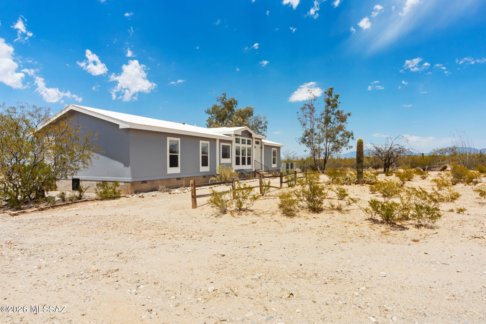 Situated on 4.71 acres of Saguaro-studded desert land, this 2,062-sq.ft., four-bedroom, two-bathroom home is your perfect oasis, complete with horse stables, arena, and a POOL. Nestled perfectly on the lot with incredible panoramic views from every window, this is the perfect place to homestead and truly unwind. Two large family rooms, separated by a wood-burning see-through fireplace, and two dining areas + breakfast bar means there is plenty of space for everyone to spread out. The kitchen is spacious with an island, a peninsula, storage galore, and a large skylight to flood the space with cozy natural light. All appliances stay!

A split bedroom floor plan ensures privacy between you and the little ones or your guests! The primary bedroom is spacious with a large walk-in closet and bathroom with a garden tub, shower stall, and plenty of storage. Across the home you'll find three spacious bedrooms and the guest bathroom. The laundry room has space for a second fridge or freezer + a large prep sink and storage with access to the exterior. The backyard is walled for privacy and includes a turf patio and above-ground pool. This is the ideal space to unwind with northwest-facing views for those beautiful Southern Arizona sunsets. 

Take a short walk over to the horse stalls/stables and riding arena. The storage sheds can be used as a workshop and/or feed and tack storage. On the lot you will also find a generously sized dog/livestock run and chicken coop, ready for your furry friends. Recent improvements include a new heat pump, reconstructed horse accommodations with coverage, and roof coating. A short drive from I-10 with convenient access to shopping and dining. This is the perfect blend of privacy and accessibility, ready for you! Come take a look - you'll never want to leave. ***Not FHA eligible due to water well.