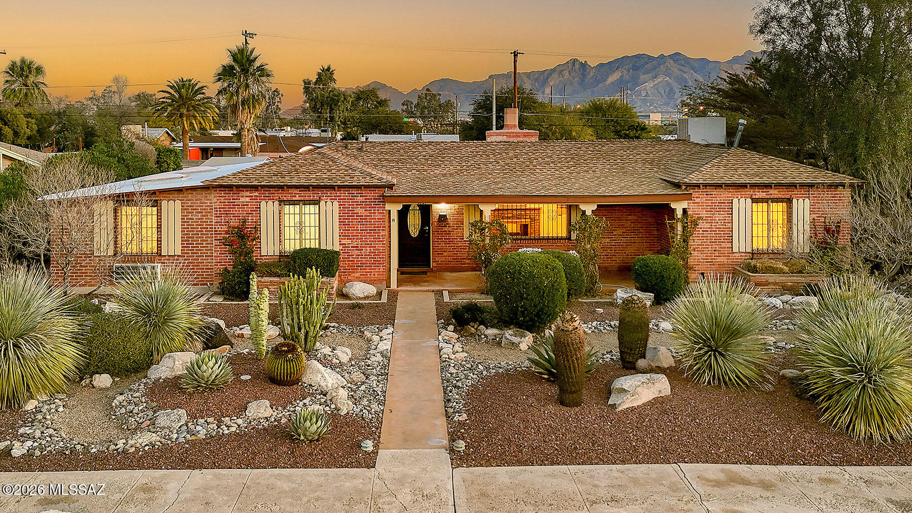 Sam Hughes 1954 home offers 3 bedrooms and 2.5 baths. Brand new roof (2026) and newly installed colored concrete floors throughout, The inviting living room features a stacked-stone fireplace and a picture window overlooking the mature desert landscaping of the front entry courtyard, living room includes dining/breakfast area. The kitchen offers ample storage and opens to a separate family room with classic mission tile floors, a full bathroom, and a built-in entertainment center, ideal for flexible living or guests. The second and third bedrooms share a vintage hall bathroom, while an additional activity room provides direct access to the backyard. Outside, enjoy a private, walled pool with views of the Santa Catalina Mountains. The oversized lot offers space to add a garage, guest hse, or studio. Newer HVAC (2020), Unbeatable location within walking distance to the University of Arizona, local restaurants, Himmel Park, bike paths, and more.