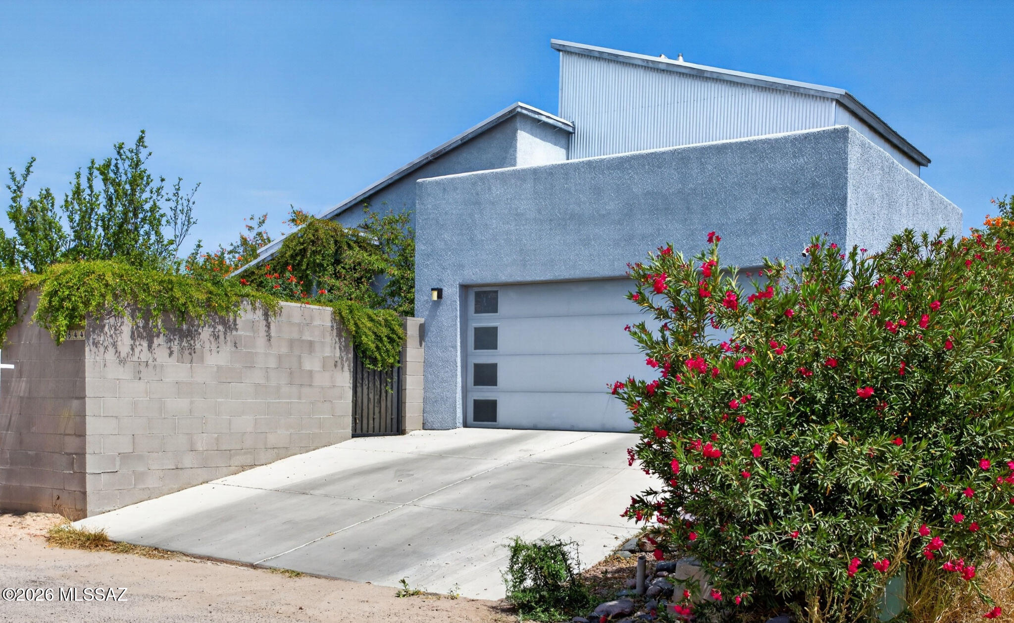 This Urban Modern design is exactly what everyone is looking for!  2-car garage, NO HOA, and a rare private courtyard entry that wraps around to the backyard. Surrounded by mature trees, flowering shrubs, and lush landscaping, the outdoor spaces offer private garden-like settings, complete with two serene koi ponds.
This loft-inspired floor plan features soaring ceilings and an open-concept great room filled with natural light. Two bedrooms are located on the main level, while a modern staircase leads to the private upstairs primary suite. 
The huge kitchen features a double-sided island with bar seating, quartz countertops, stainless steel apron sink, decorative pendant lighting, stainless steel appliances and an extensive tiled backsplash. 
Both bathrooms are designed with tiled showe surrounds, quartz countertops, undermount sinks, modern plumbing fixtures and lighting. 

Large laundry room includes the washer and dryer for a truly turn-key home! 

Ideally located just 1 mile from the University of Arizona, tucked behind Beyond Bread and only 1.5 miles from downtown Tucson's vibrant dining, coffee and brewery scene!